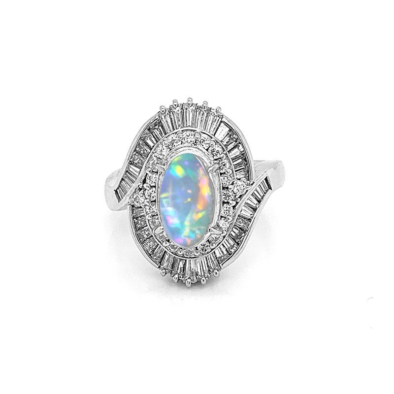 A superb ring hand fabricated in platinum. It features a 2.60 carat crystal opal with brilliant play of color. Bright flashes of red, green and orange dance across the dome of this precious opal. It is accented by 1.74 carats of VS quality diamonds,