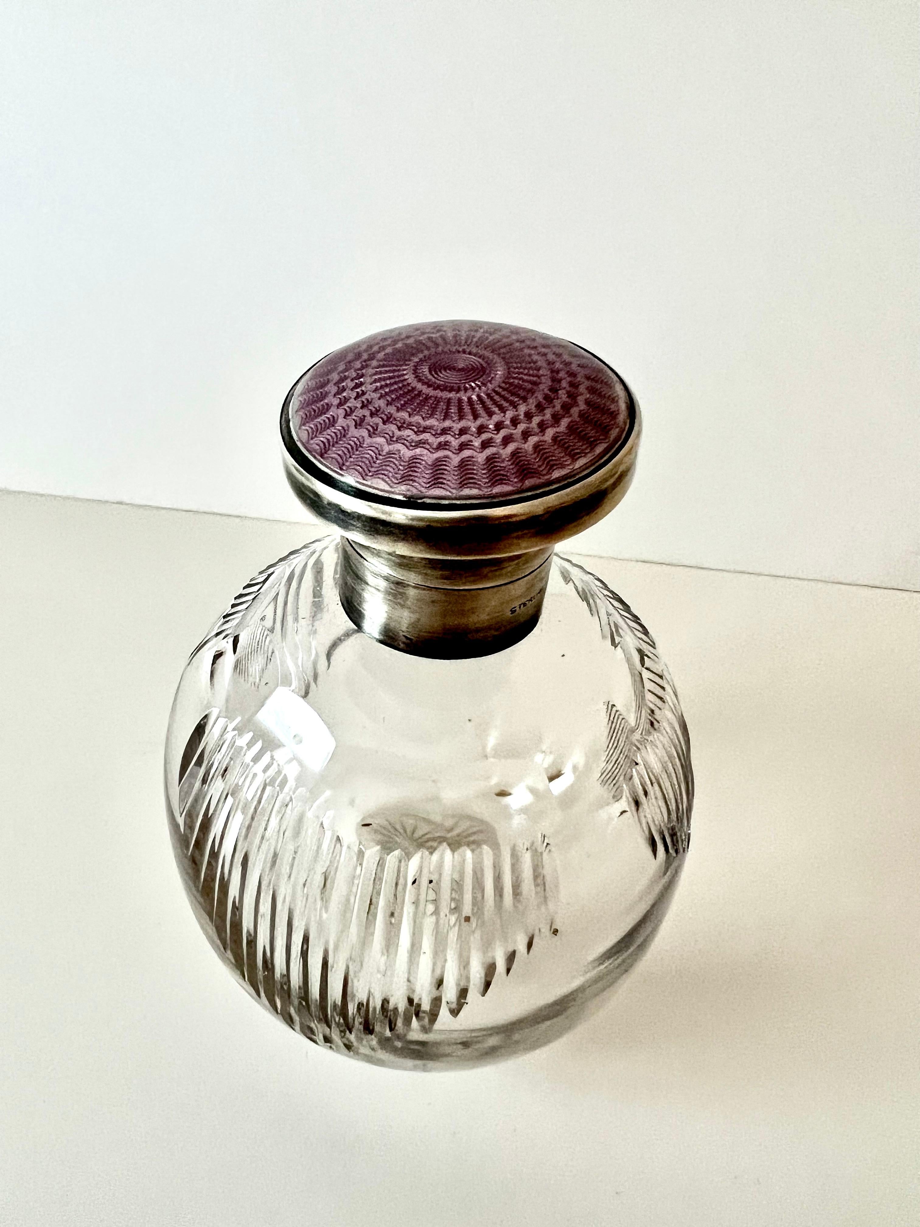 Un bellissimo flacone di profumo con chiusura in argento e smalto guilloché alla lavanda. Un complemento d'arredo per qualsiasi tavolo da toilette, spogliatoio, vanity o vicino alla vasca da bagno... uno splendido pezzo di vetro trasparente che non