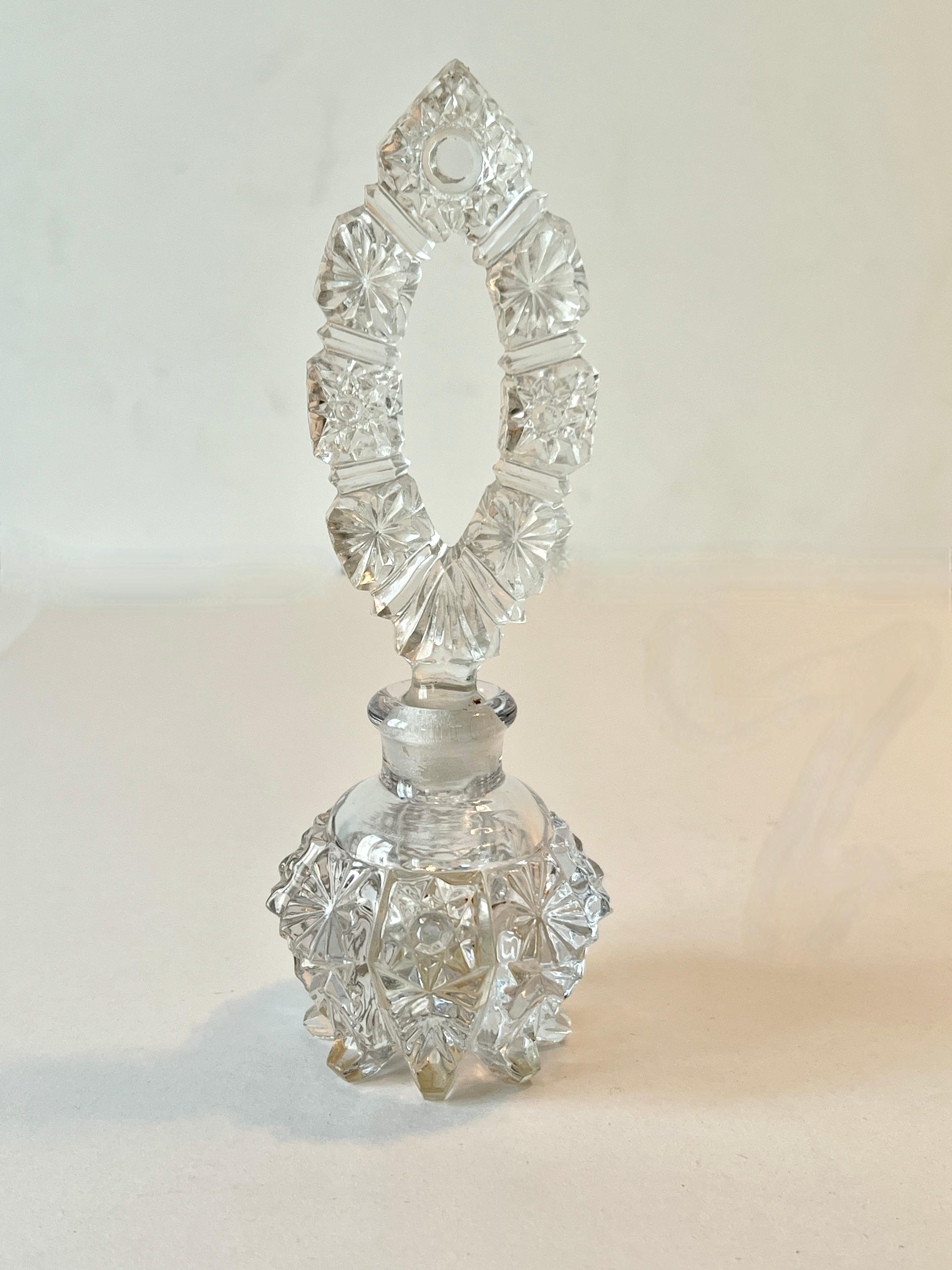 Un magnifique flacon de parfum en verre taillé ou en cristal.  La bouteille bulbeuse avec le bouchon allongé assorti est une belle combinaison.

Cette pièce peut être utilisée seule ou en complément d'autres flacons de parfum sur un meuble de