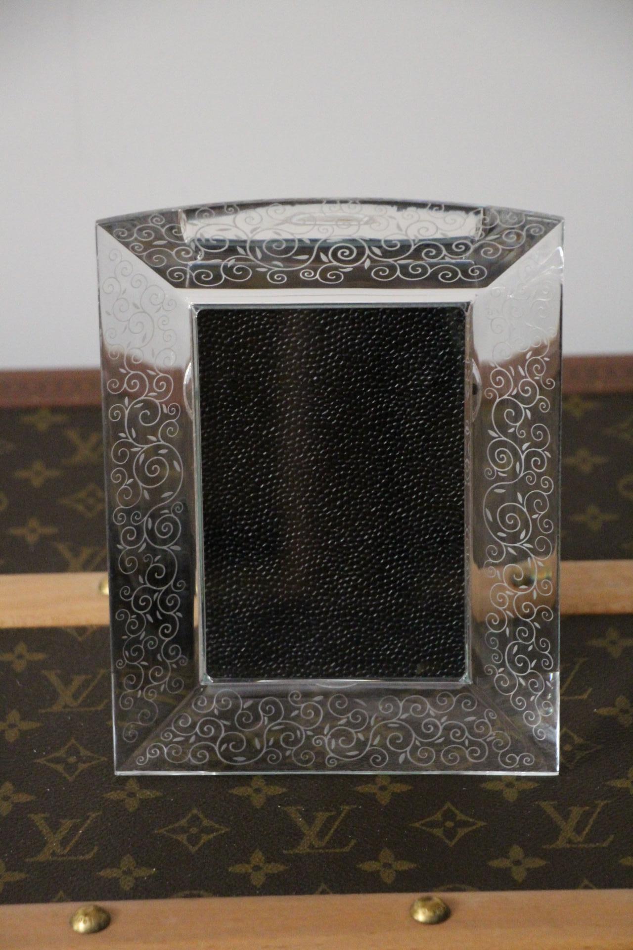This superb picture frame in crystal was made by the famous luxury French Baccarat company, situated in East of France .Its design is modern and classical at the same time. Its engraved motifs were made by hand in Baccarat worksop.It is signed on