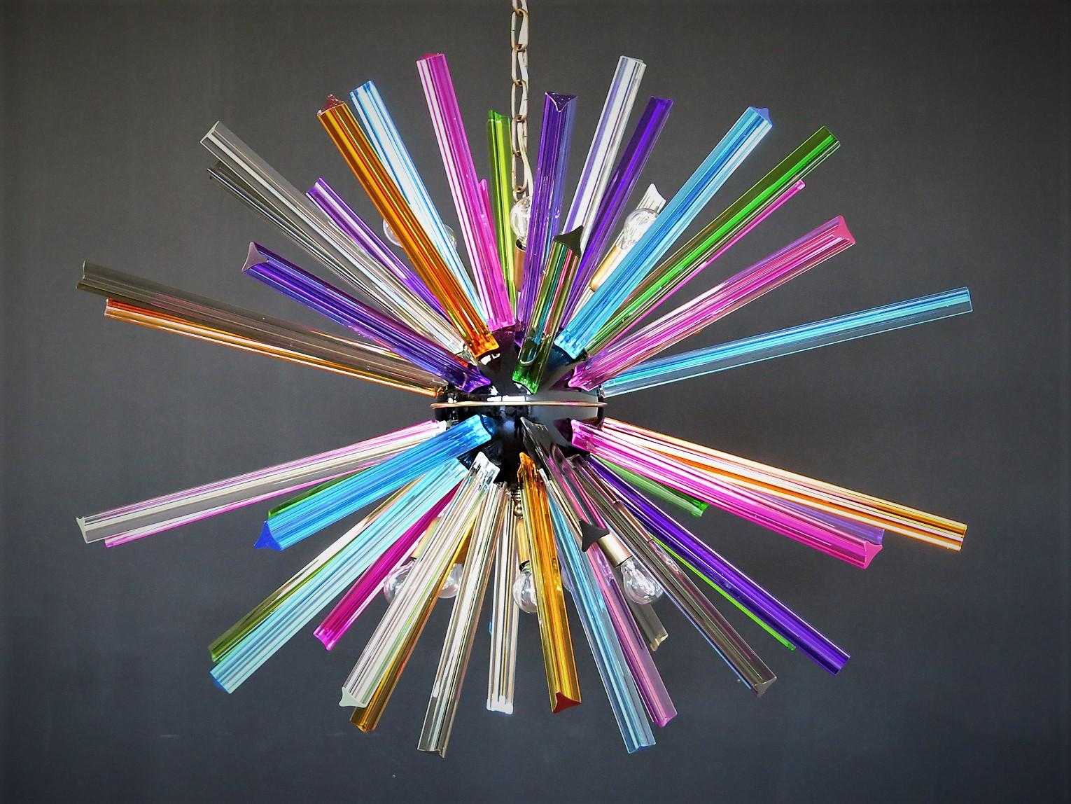 Lustre Spoutnik entourant 50 prismes «triedri » en verre de cristal multicolore rayonnant à partir d'un nucle central en métal noir. Support de lampe en laiton.
Période : fin du XXe siècle
Dimensions : 130 cm de hauteur avec chaîne ; 70 cm de