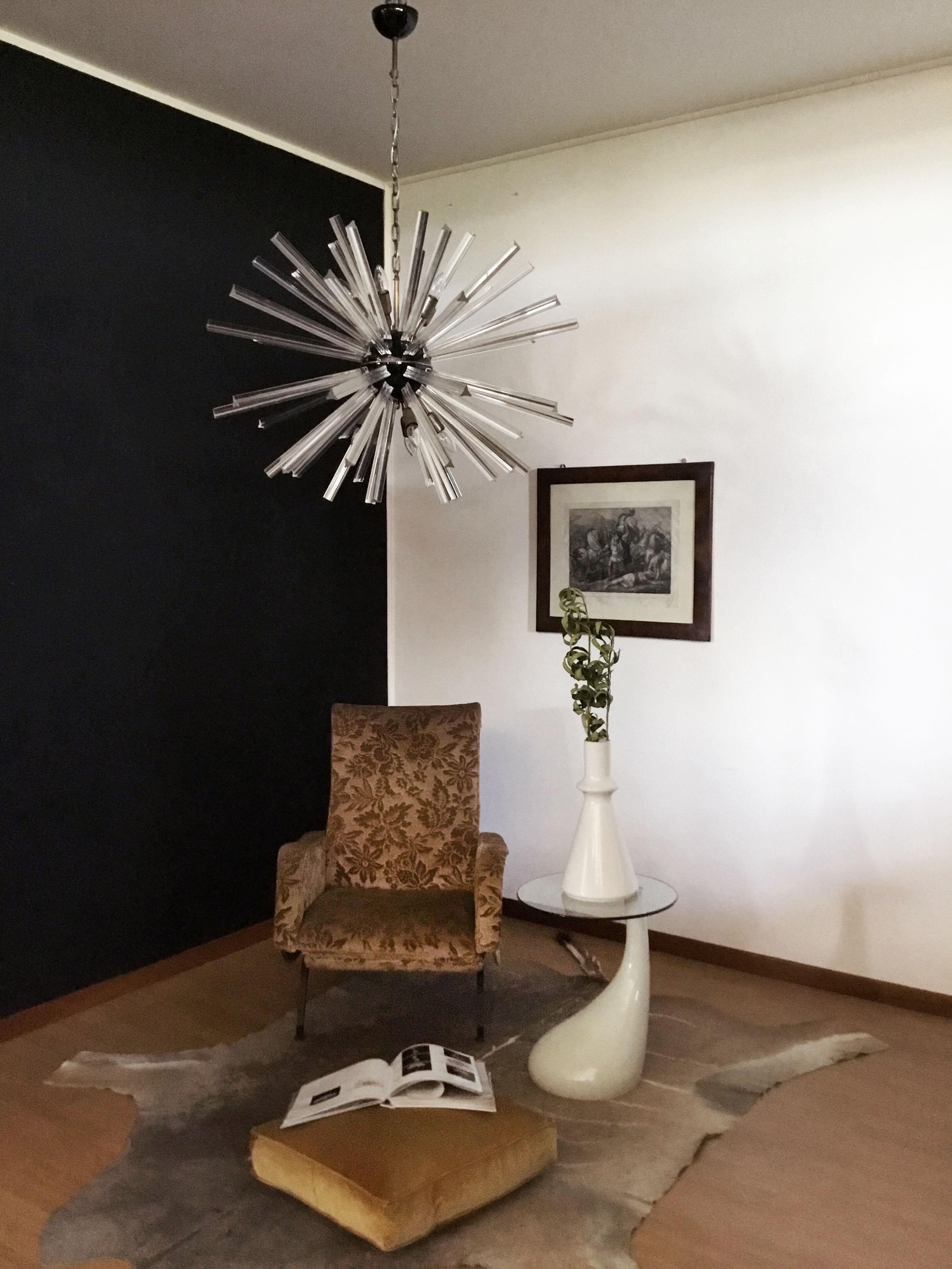 Sputnik chandelier surrounding 50 crystal glass 'triedri' prisms radiating from a center black metal nucleus. Brass lamp holder.
Period: late 20th century
Dimensions: 51,20 inches (130 cm) height with chain; 27,55 inches (70 cm) height without