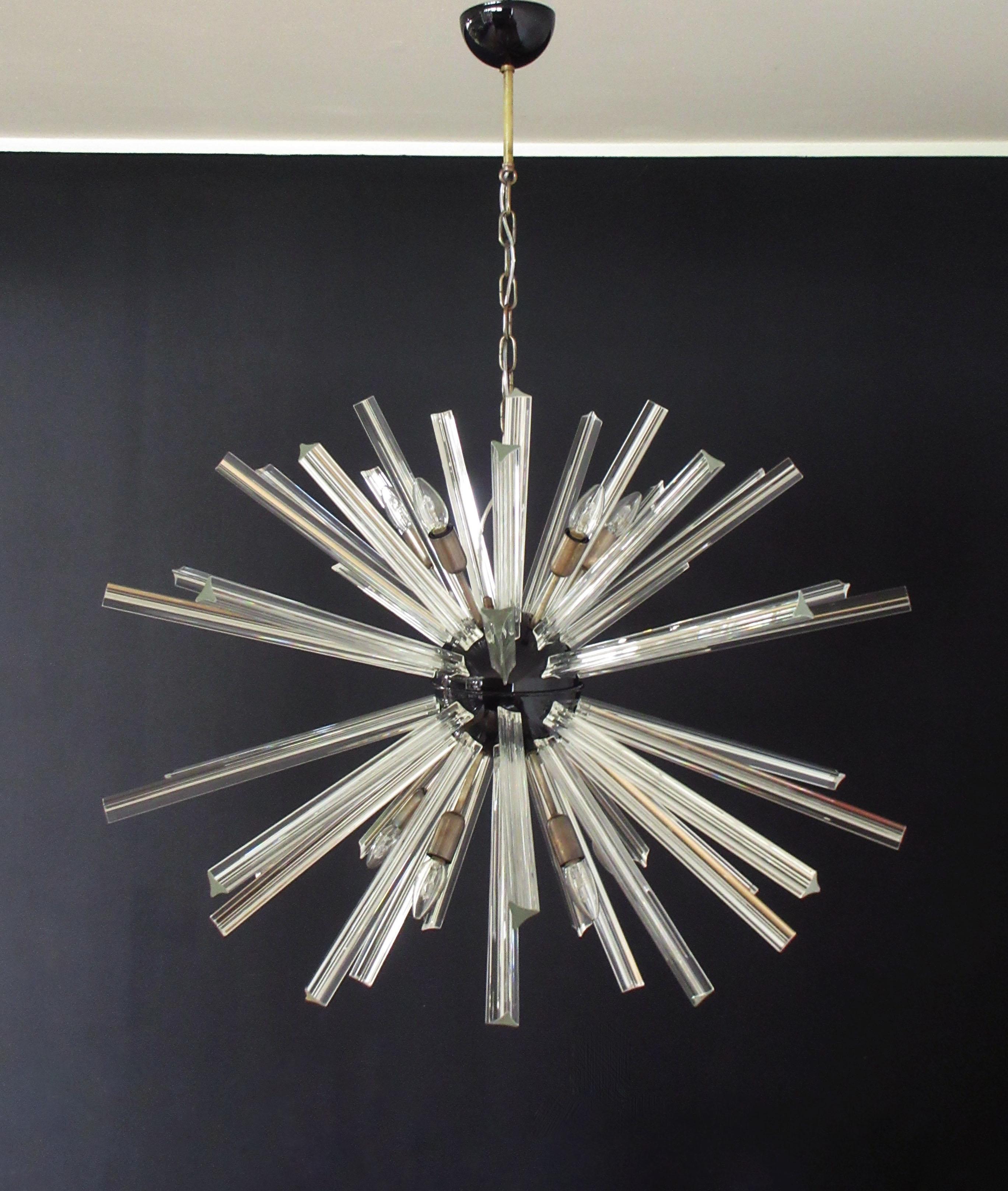 Sputnik chandelier surrounding 50 crystal glass 'triedri' prisms radiating from a center black metal nucleus. Brass lamp holder.
Period: Late 20th century
Dimensions: 51.20 inches (130 cm) height with chain; 27.55 inches (70 cm) height without