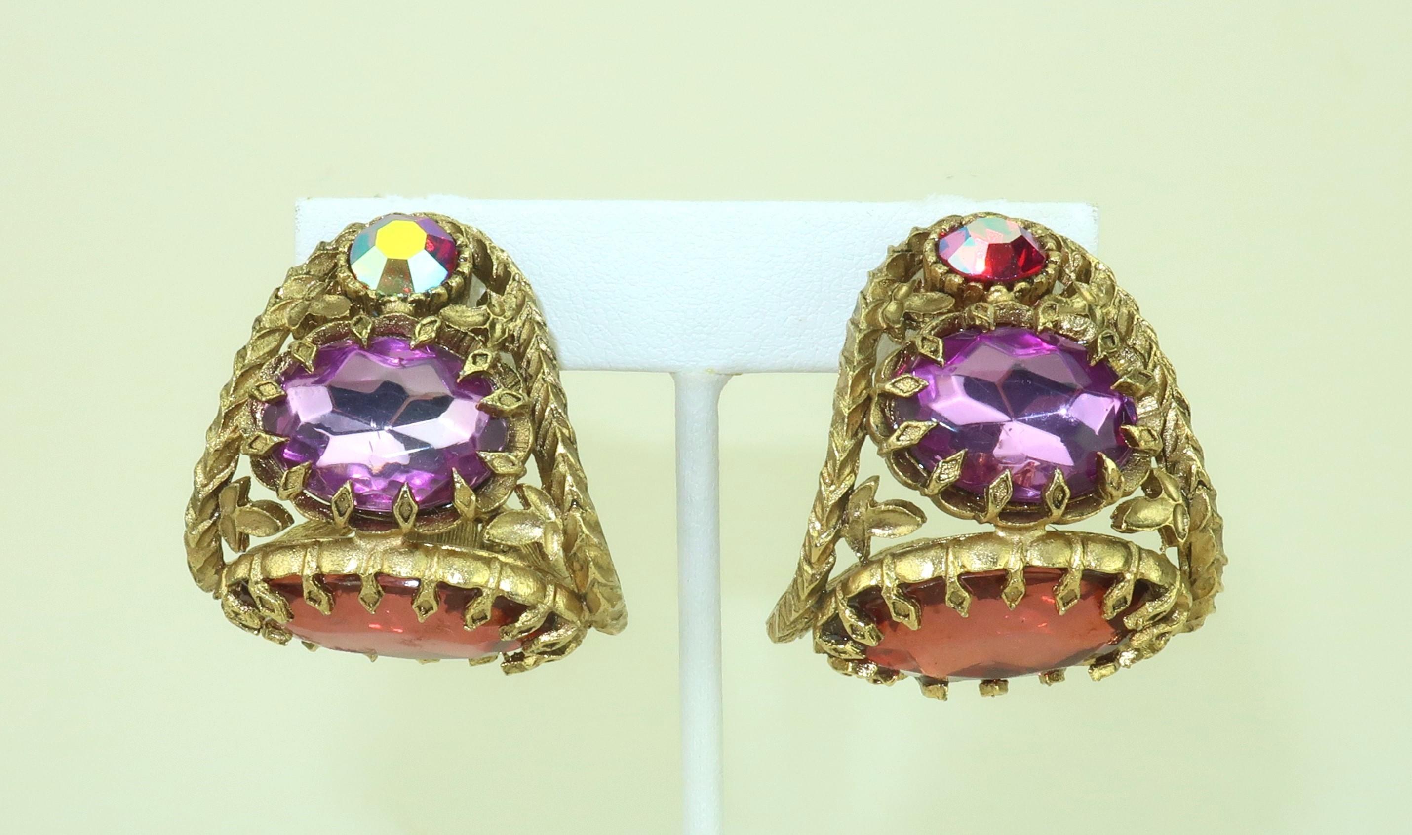 Orecchini a clip in cristallo sfaccettato del 1990 con montatura in oro dorato che riproduce fiori rampicanti.  I cristalli sono una combinazione di viola ametista, rosso anguria e rosso rubino iridescente.  Il design opulento sarà un tocco
