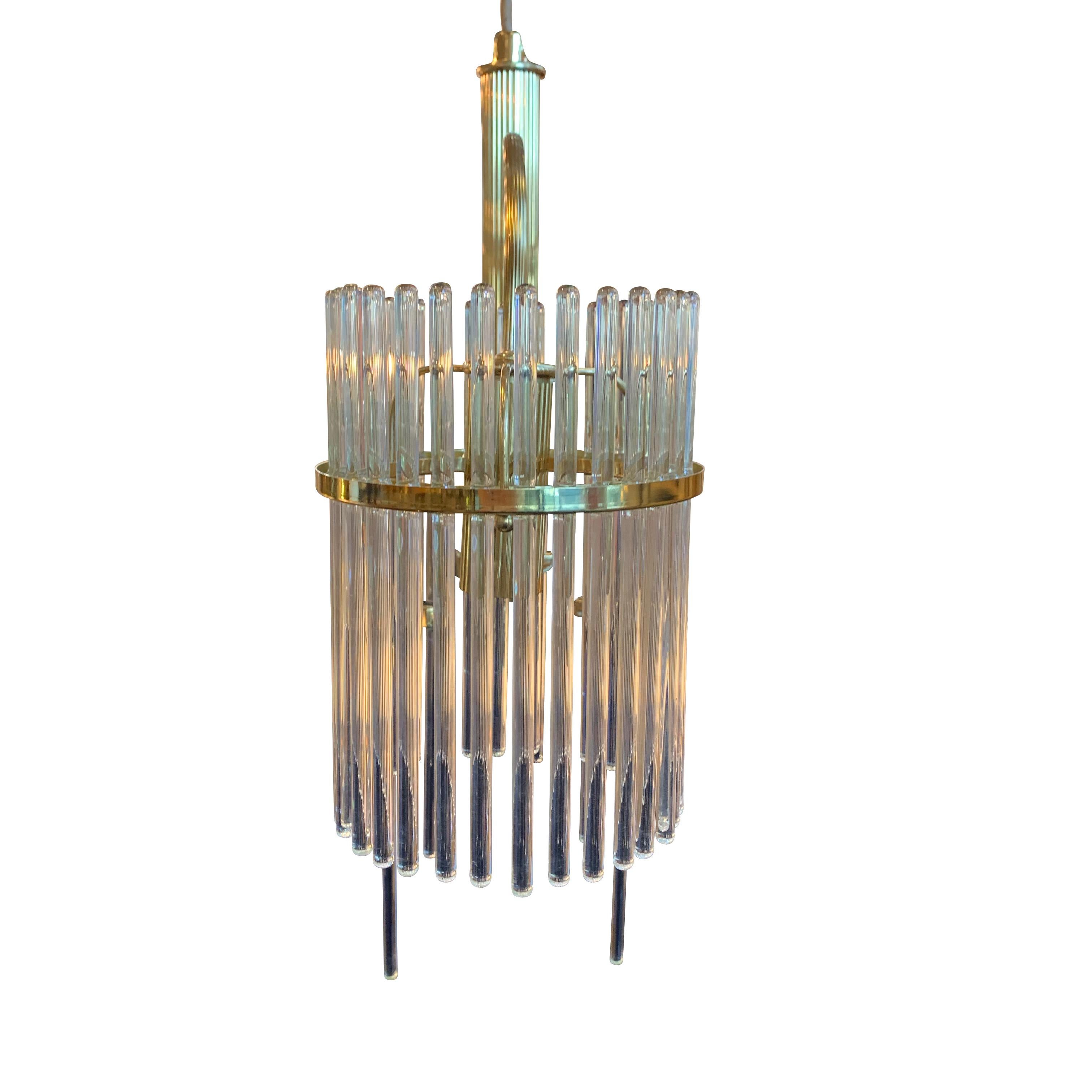 Italian design Sciolari three-arm chandelier
The signature thin crystal rods circle a brass ring on each arm.
Five decorative brass arms are decorative and hold additional crystal rods.
The vertically ribbed center brass rod has a single bulb at