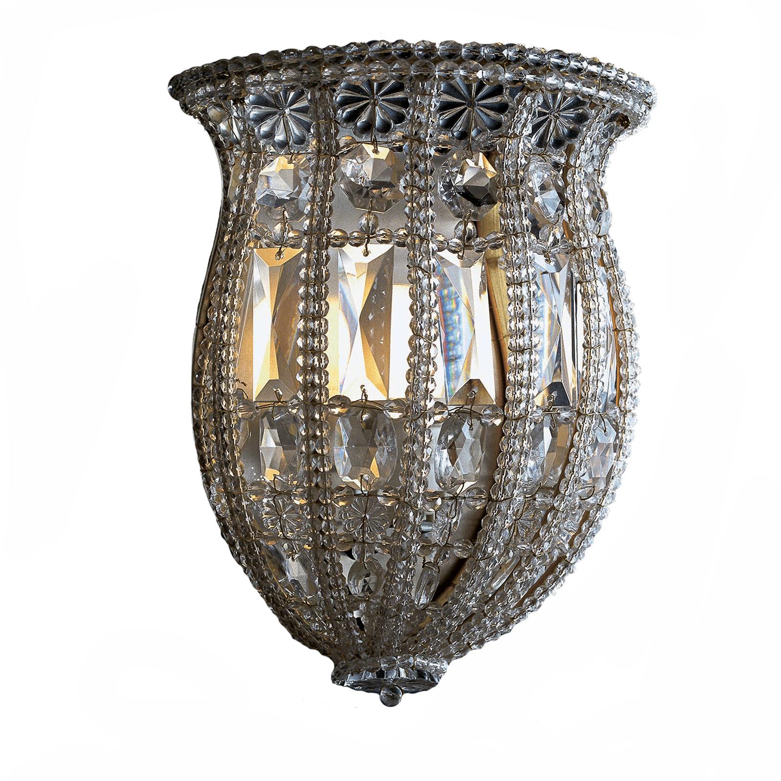 This elegant sconce is an exquisite example of fine, traditional craftsmanship, combined with a sinuous shape that creates a timeless design sure to make a statement in any decor. The structure, opening up at the top like a large-mouthed vase, is