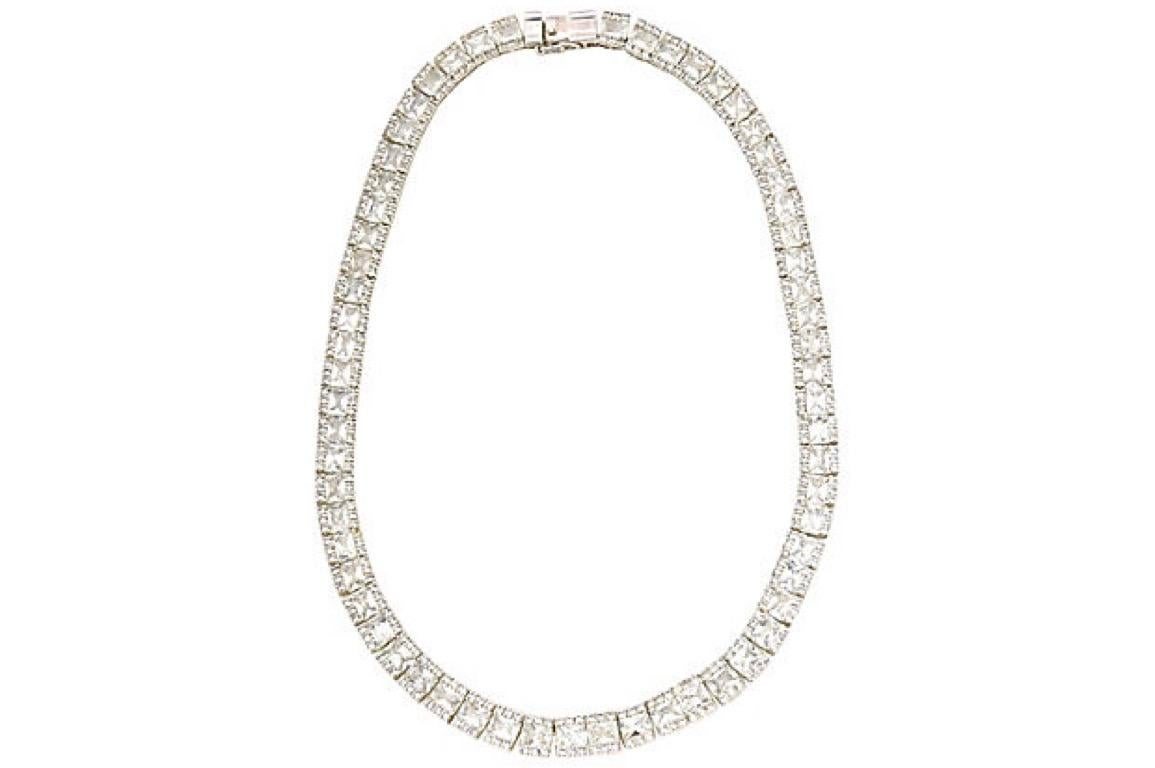 Necklace featuring clear crystals that imitate diamonds mounted in a sterling silver mounting. Push button clasp with a security side clasp. Marked: 925. Age wear.
