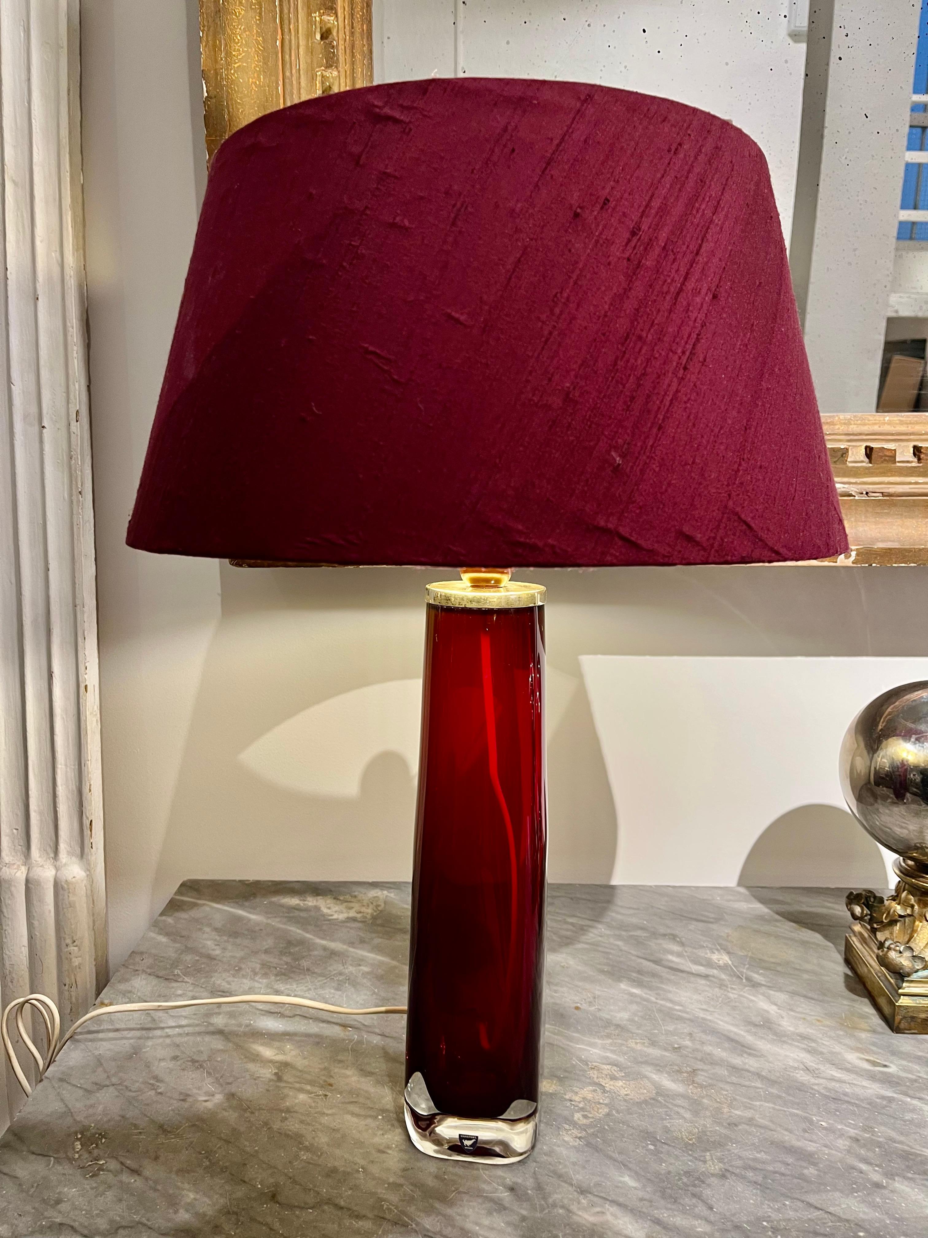 An Orrefors red glass table lamp with chrome fittings, designed by Carl Fagerlund in the 1960s.