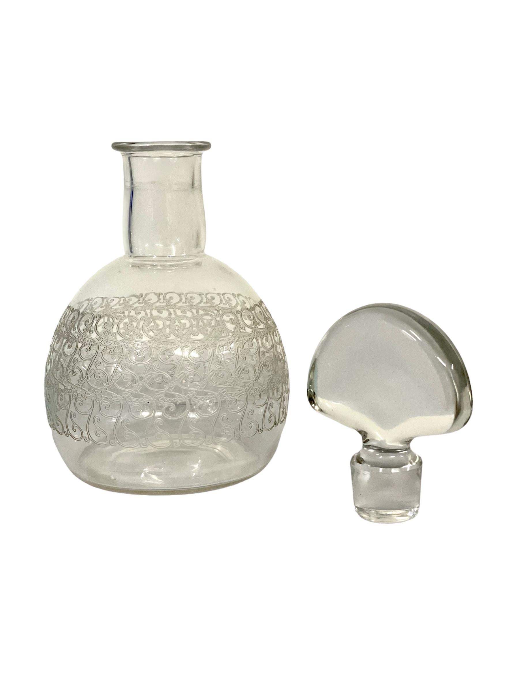 A stunning crystal wine decanter with stopper from the renowned house of Baccarat, part of the exquisite 'Rohan' collection. Decorated in a wide band across its wide bowl with a recurring S-shaped swirling motif, beautifully coiled and delicately