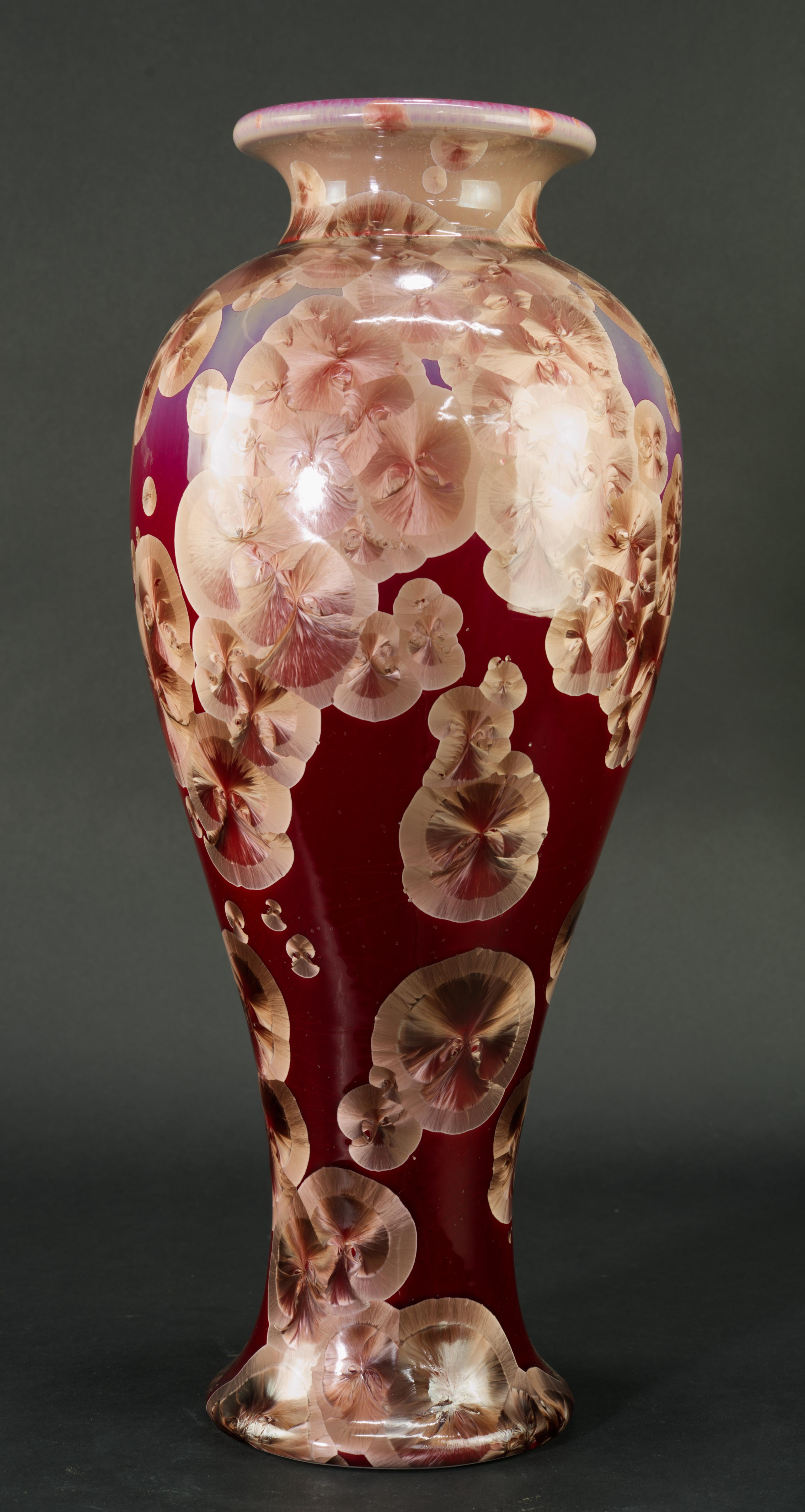 
Le vase monumental en céramique de Studio pottery est décoré d'une glaçure cristalline dans une palette saisissante de rouge foncé et de beige. Le vase a été jeté à la main sur un tour ; les cristaux de couleur beige sur une base de couleur ombre,