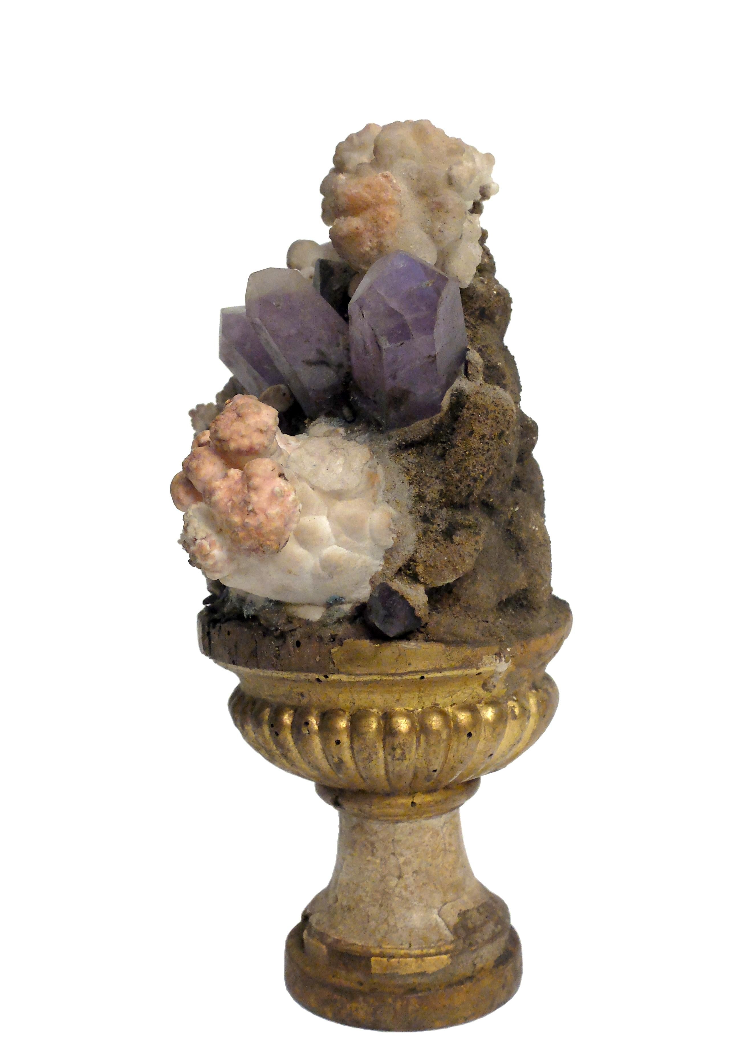 A natural mineral specimen: A composition of amethyst and calcite flower crystals Druze, mounted over the guild-plated wooden base on a vase shape.