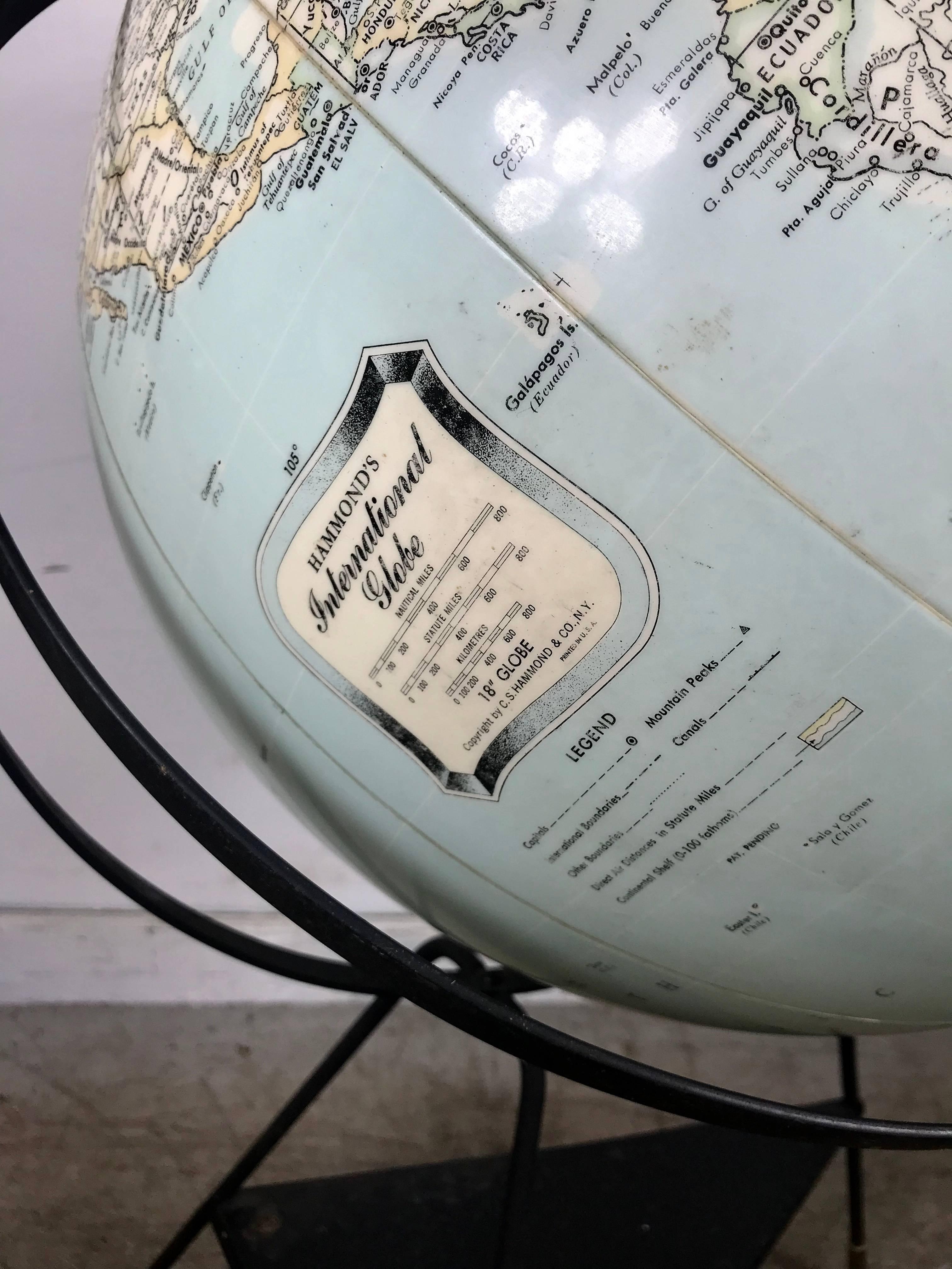 Hammond's International Globe (circa 1955) composed of an inflatable globe on painted metal tripod base. Images and font are large in scale and very legible. As durable as a beach ball, this vinyl globe is inflatable / deflatable by way of a locking