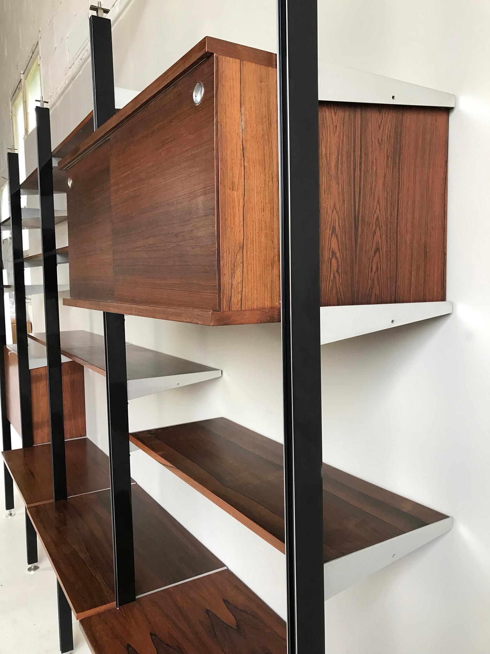 CSS modular bookcase in rosewood, floor / ceiling version by George Nelson for Mobilier International, 1960s.
She can position against a wall or clautra.
It consists of:
- 5 polished black poles,
- 14 shelves (D 30.5 cm / L 85.5 cm)
- 3 shelves
