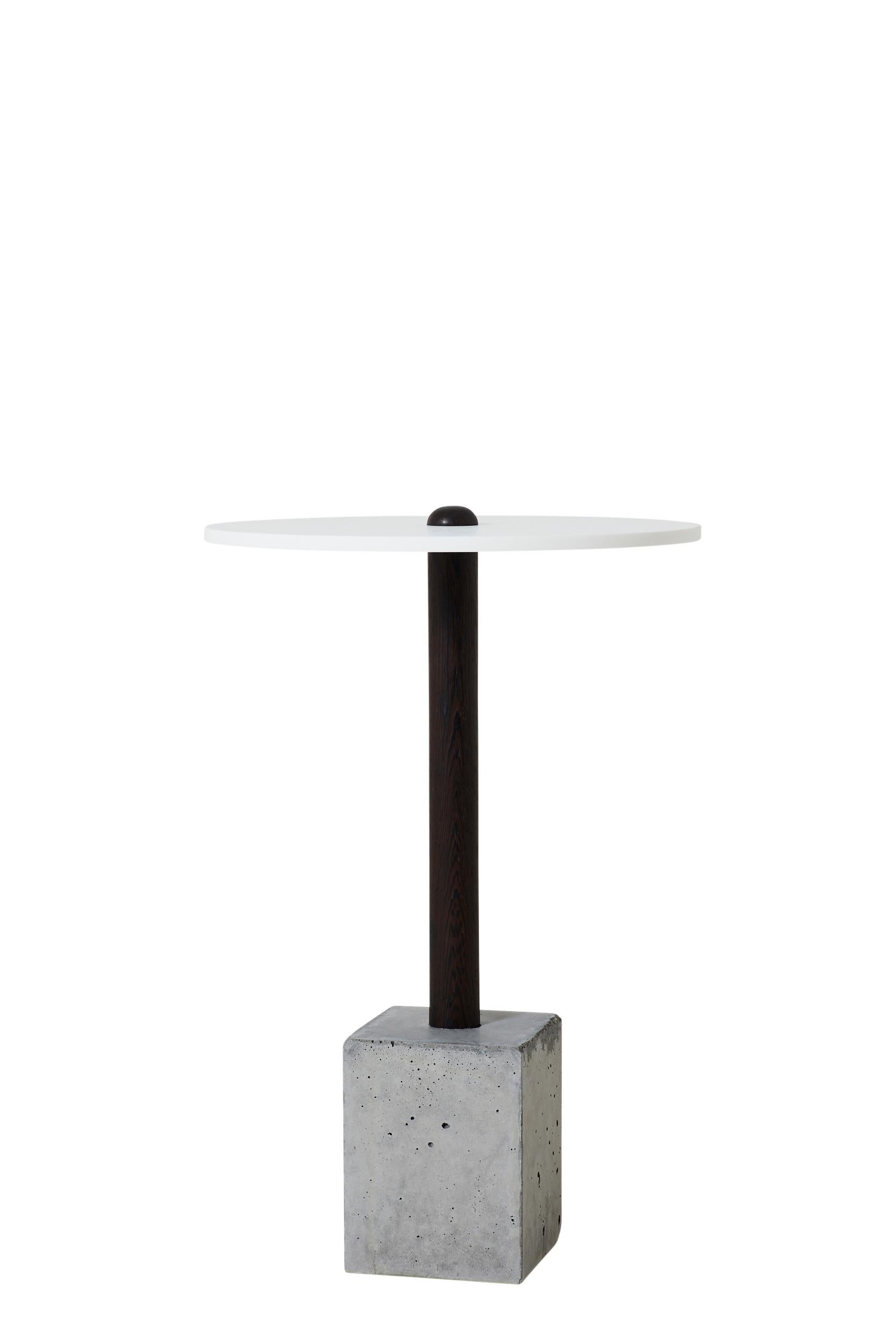 This simple and elegant design is composed of a hand-turned upright piece of wood that is cast into a concrete base. Shown in wenge, the concrete base is either a clean cube or a rougher 