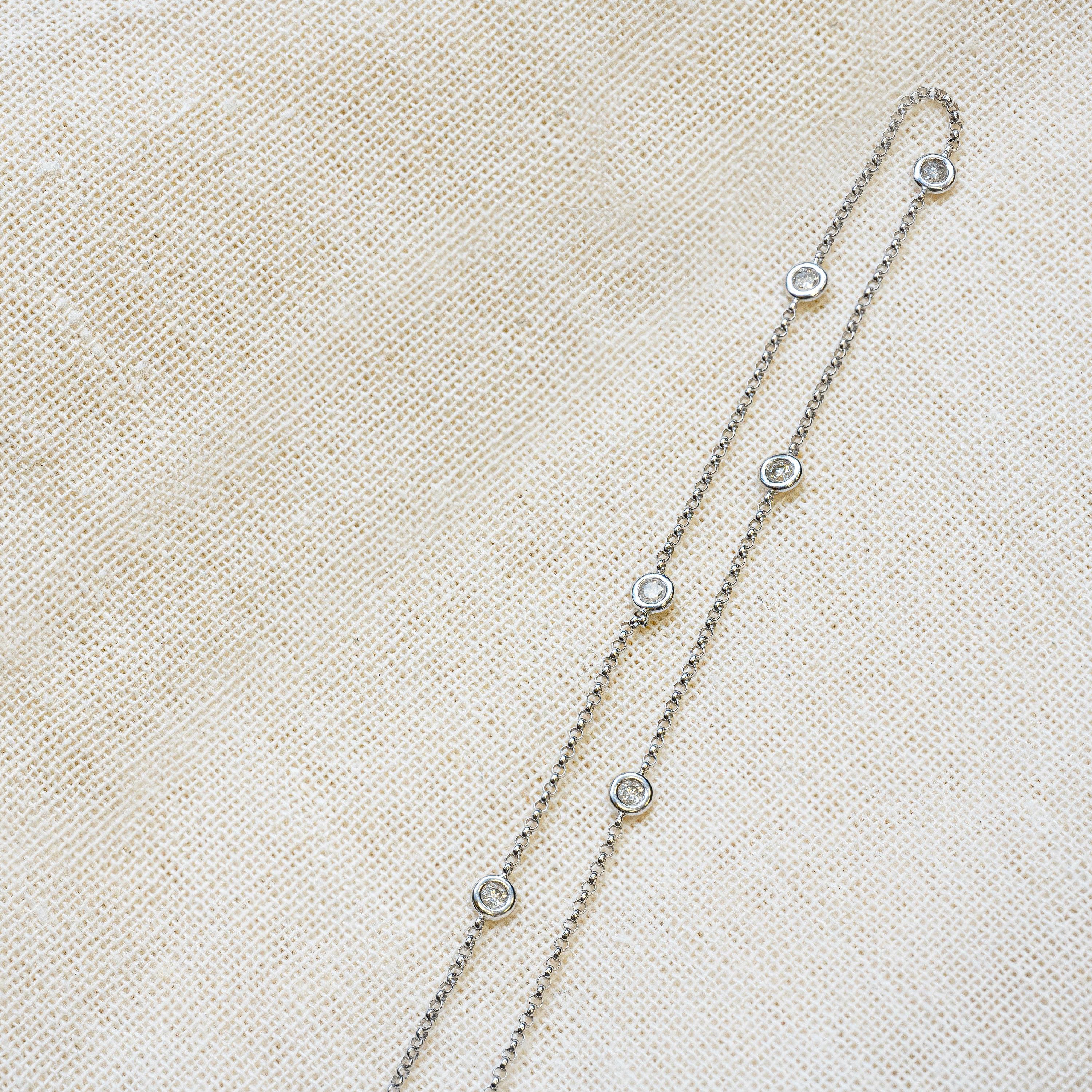 Exquisite and timeless, this 18 carat white gold station necklace highlights 7 fine quality round brilliant cut diamonds weighing 0.70ct combined. The stones are perfectly mounted in individual rub-over settings on a delicate belcher chain measuring