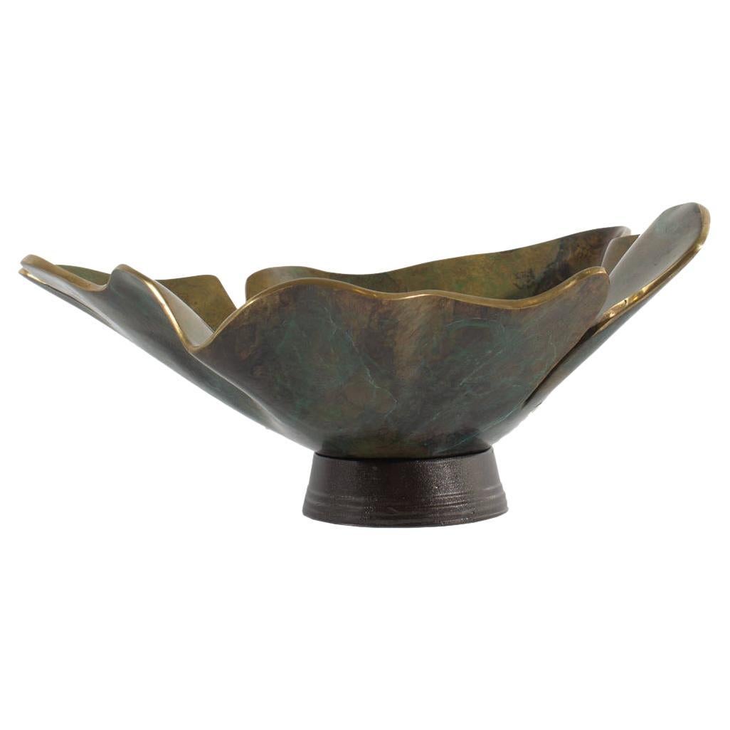 A limited edition abstract bronze sculpture by the American artist C.T. Whitehouse. Signed to the outer edge, the bronze leaf formation is organically shaped into a vessel and rests within a black resin base. Controlled oxidation and polished edges