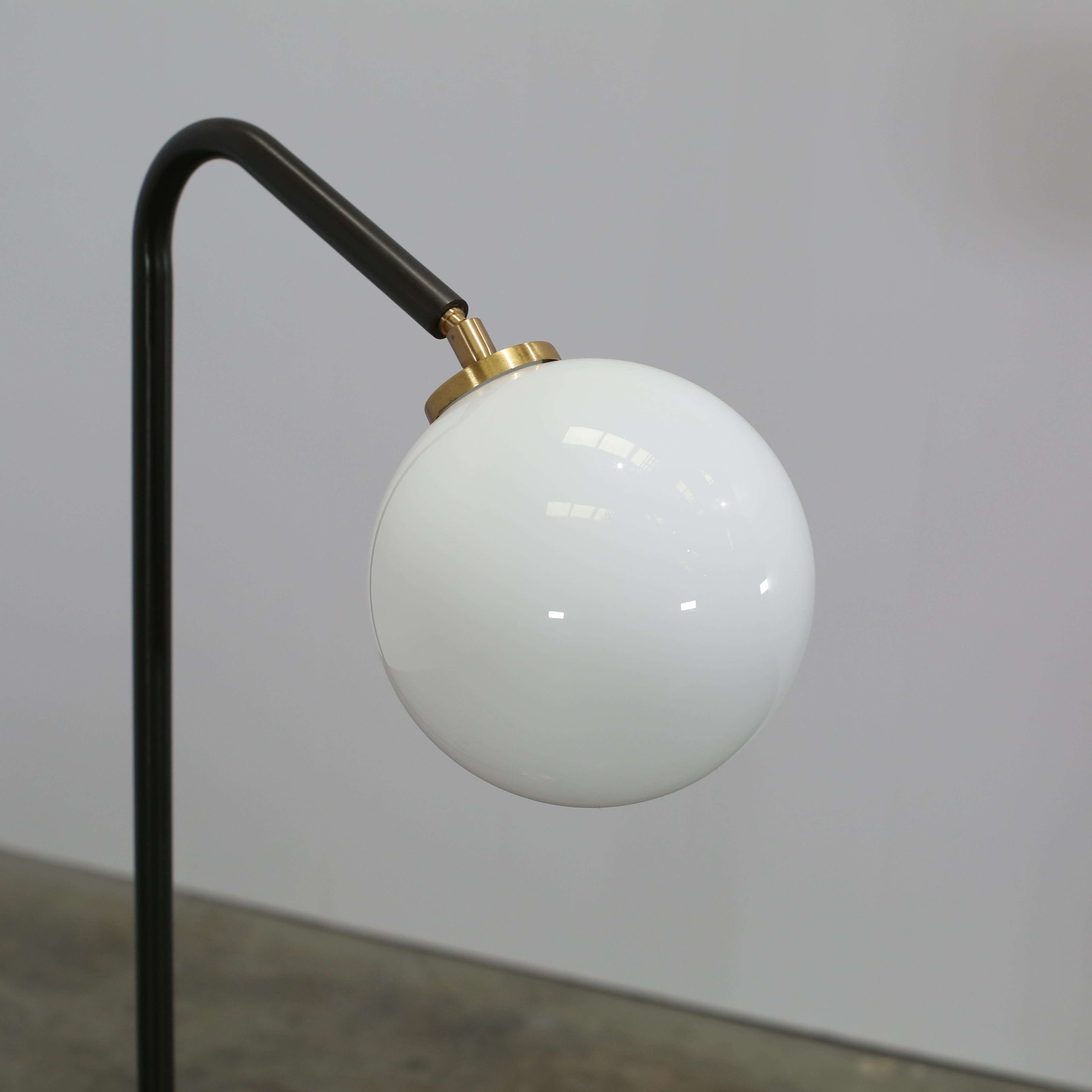 Introducing the Oscar Floor Lamp by CTO Lighting, a stunning addition to any luxury interior. This elegant lamp features a sleek, cylindrical design crafted from high-quality materials, including a delicate glass shade and a sleek metal base. The
