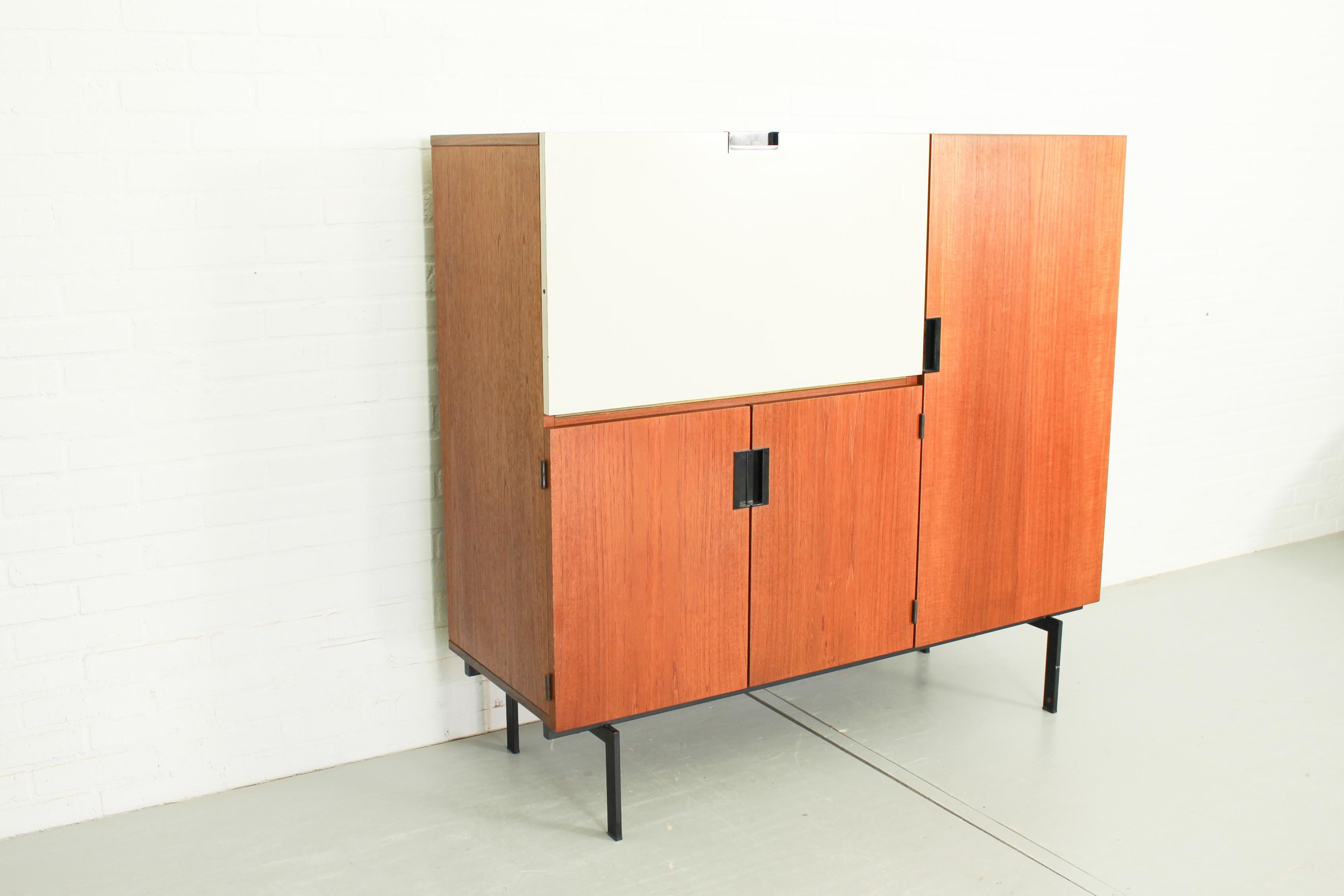Cabinet CU01 designed by Cees Braakman for UMS Pastoe in 1958. This elegant cabinet from the japanese series features a flap, which can be used as a desk top. The cabinet seems to float in the space as it has a narrow black metal base and clean