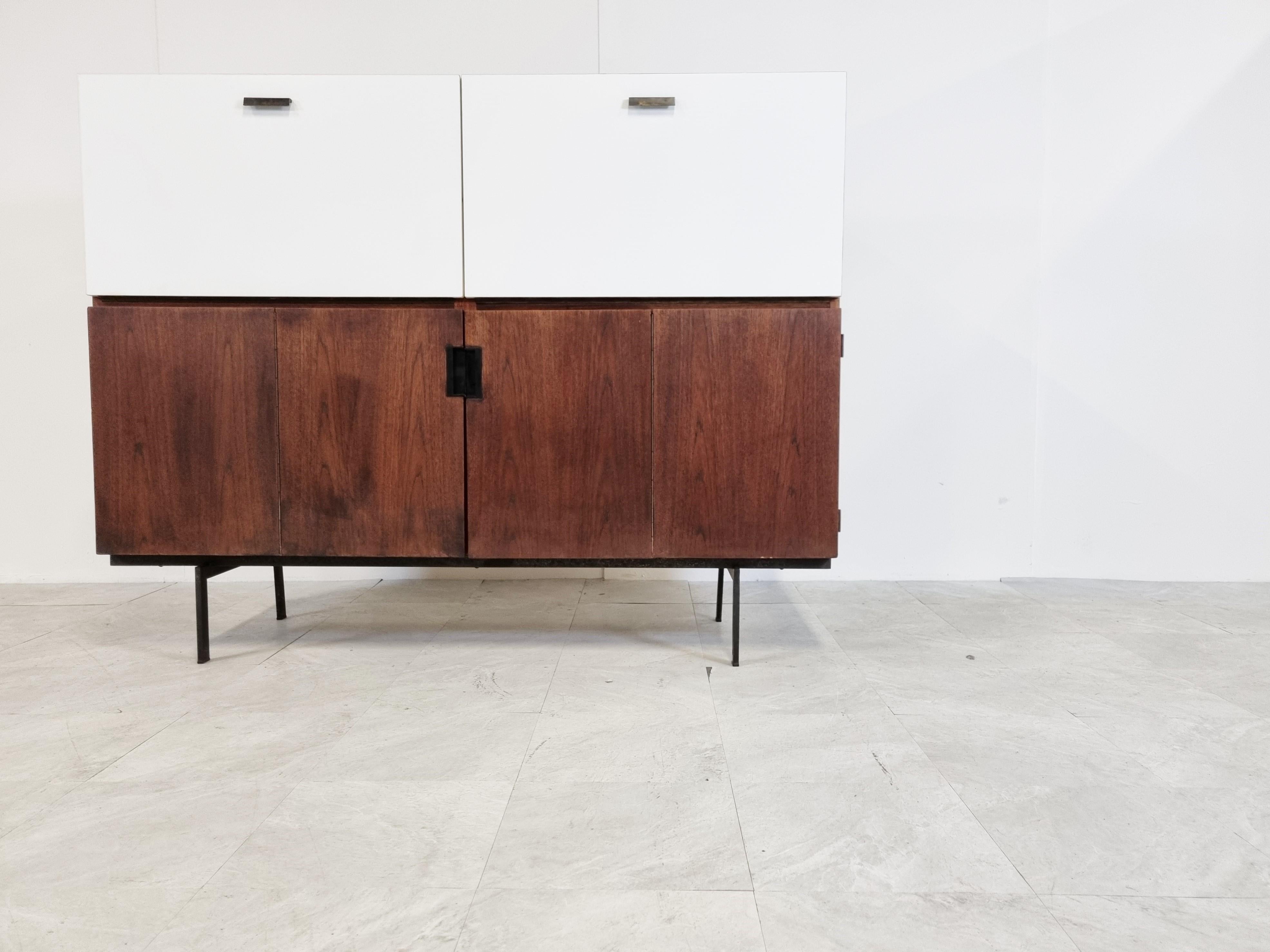 Mid-century teak cabinet designed by Cees Braakman for Pastoe 'Japanese series'.

Consists out of two double hinge doors and two white lacquered folding down doors.

Original lettre box and shelves still there.

Doorhandles have been replaced