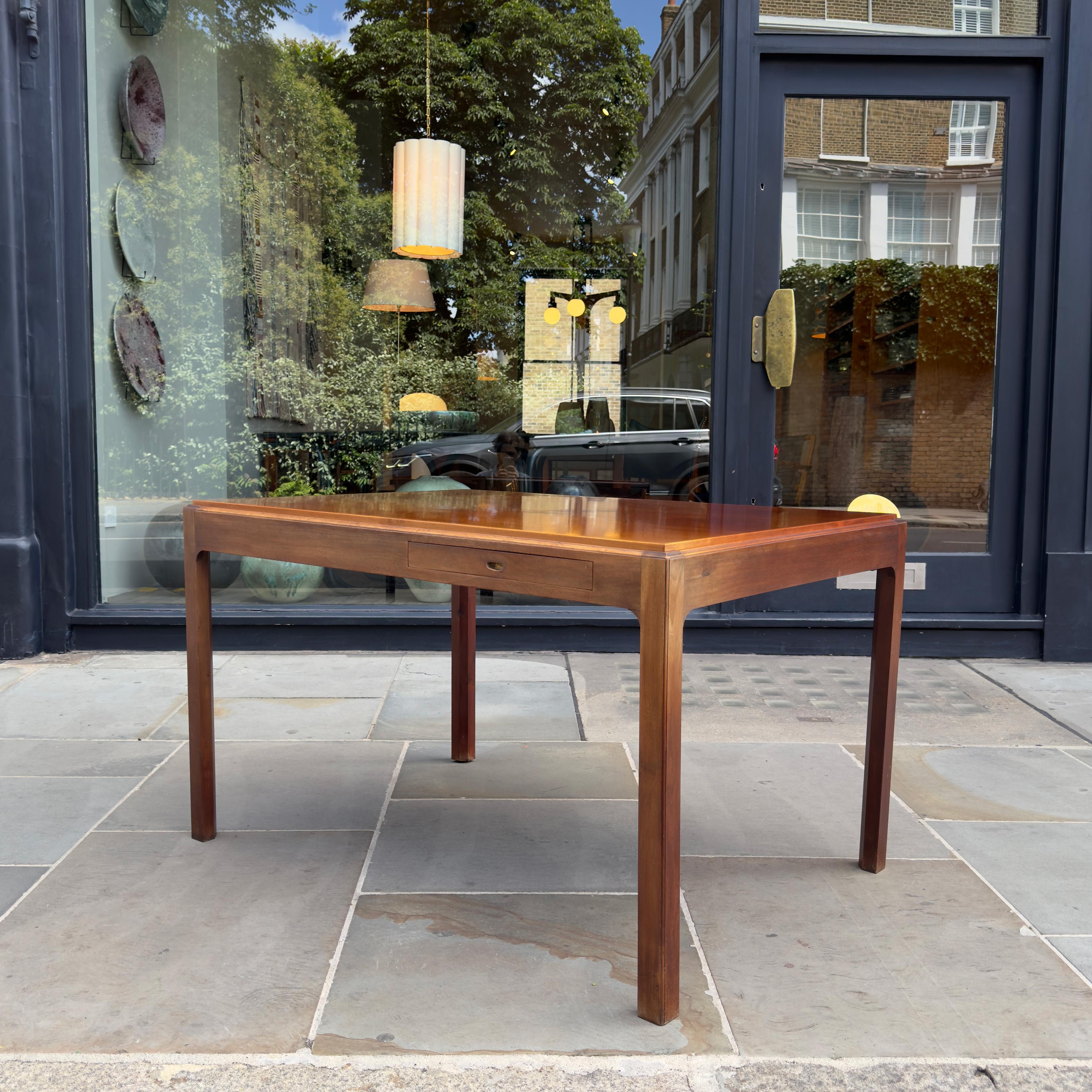 A cuban mahogany drawing table with central compartment, side drawer, and reversible lid, made in Denmark by a master cabinetmaker between 1940-1950. 

The deep proportions of this elegant piece speak of its concealed history as a drawing table,