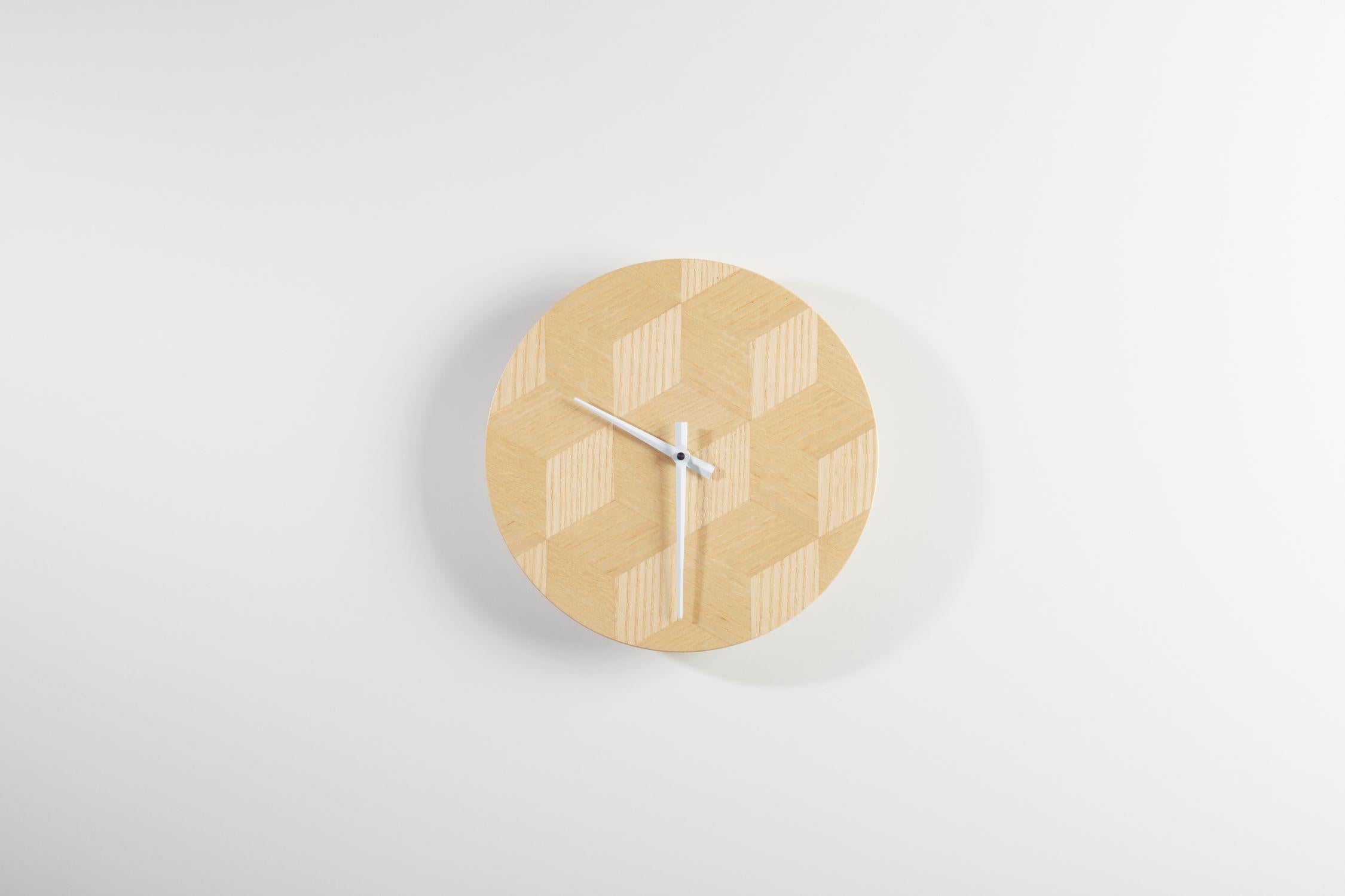 Redefine your decor with these exquisite wall clocks, showcasing a mesmerizing design crafted from natural ash veneer arranged in a 3D cube pattern. The intricate arrangement of the ash veneer creates a captivating visual effect, resembling shifting