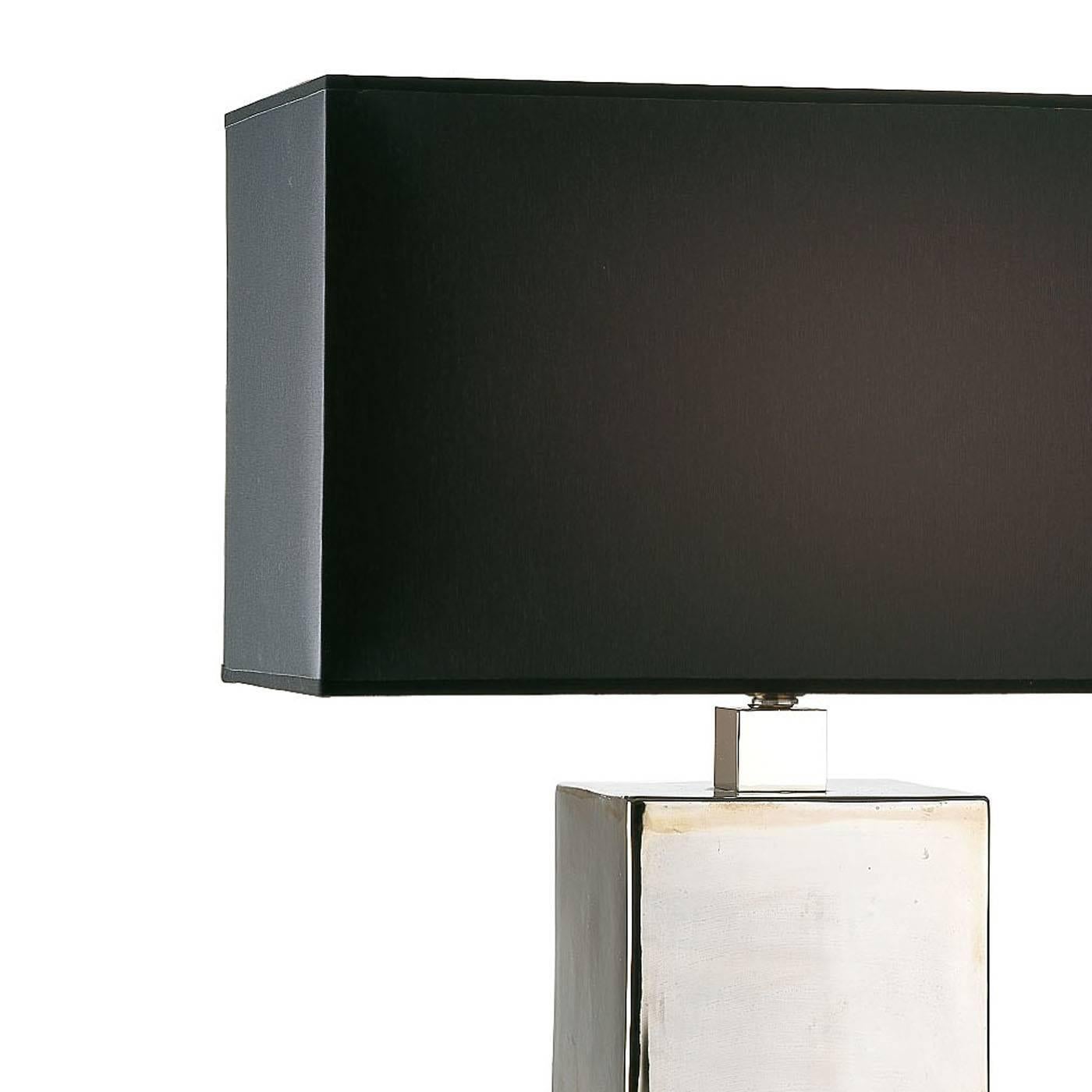 This elegant lamp exudes modern appeal thanks to its geometric silhouette, while the traditional materials used give it a classic charm, making this a timeless piece that can be a precious addition to any décor. The squared shaft, divided into three