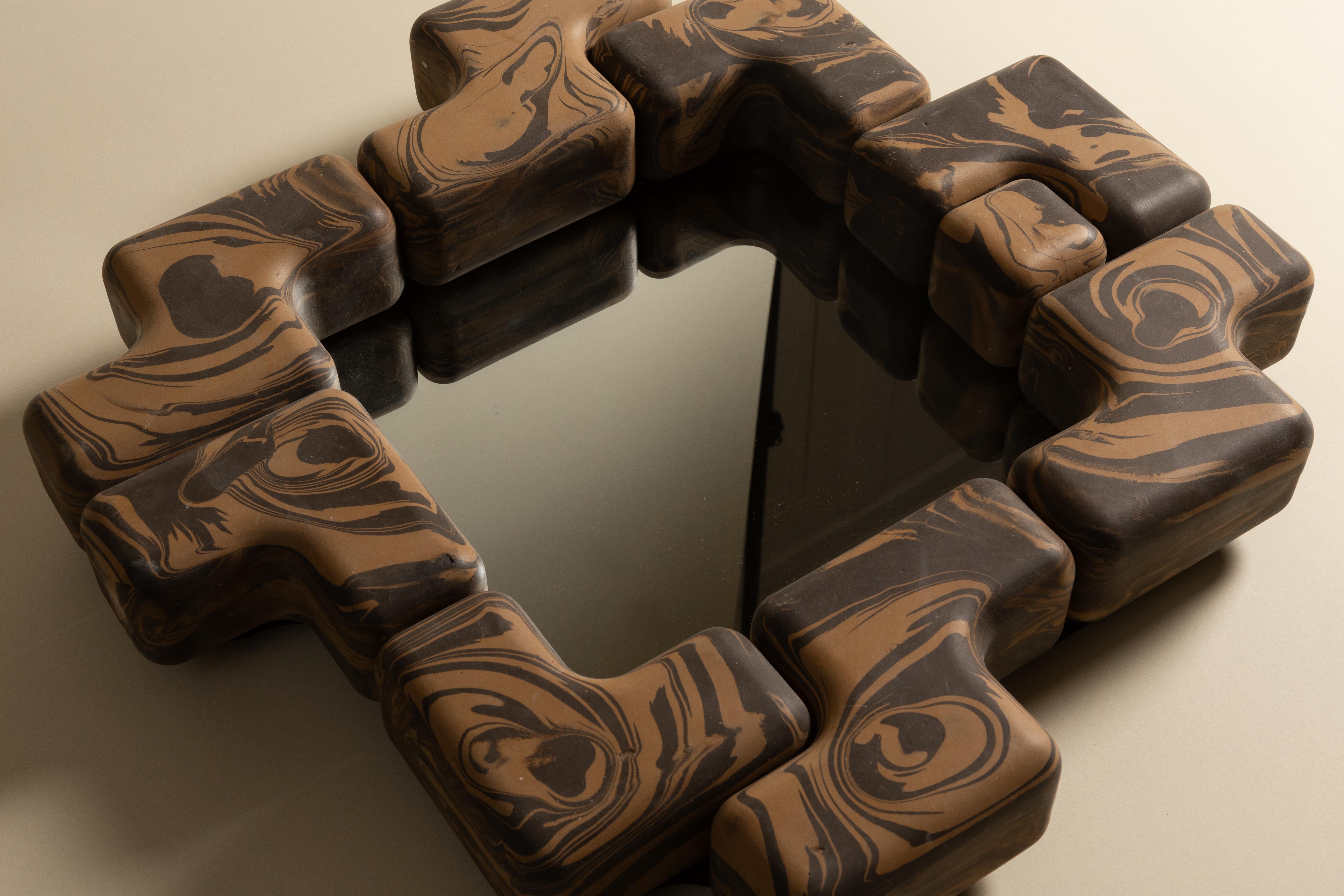 Il Cube Fit Mirror è uno specchio da parete scultoreo realizzato con forme di ceramica modulari a incastro. Fusa a mano negli Stati Uniti, l'audace cornice circonda uno specchio di vetro quadrato, creando un ritmo giocoso di geometrie ripetute. Ogni