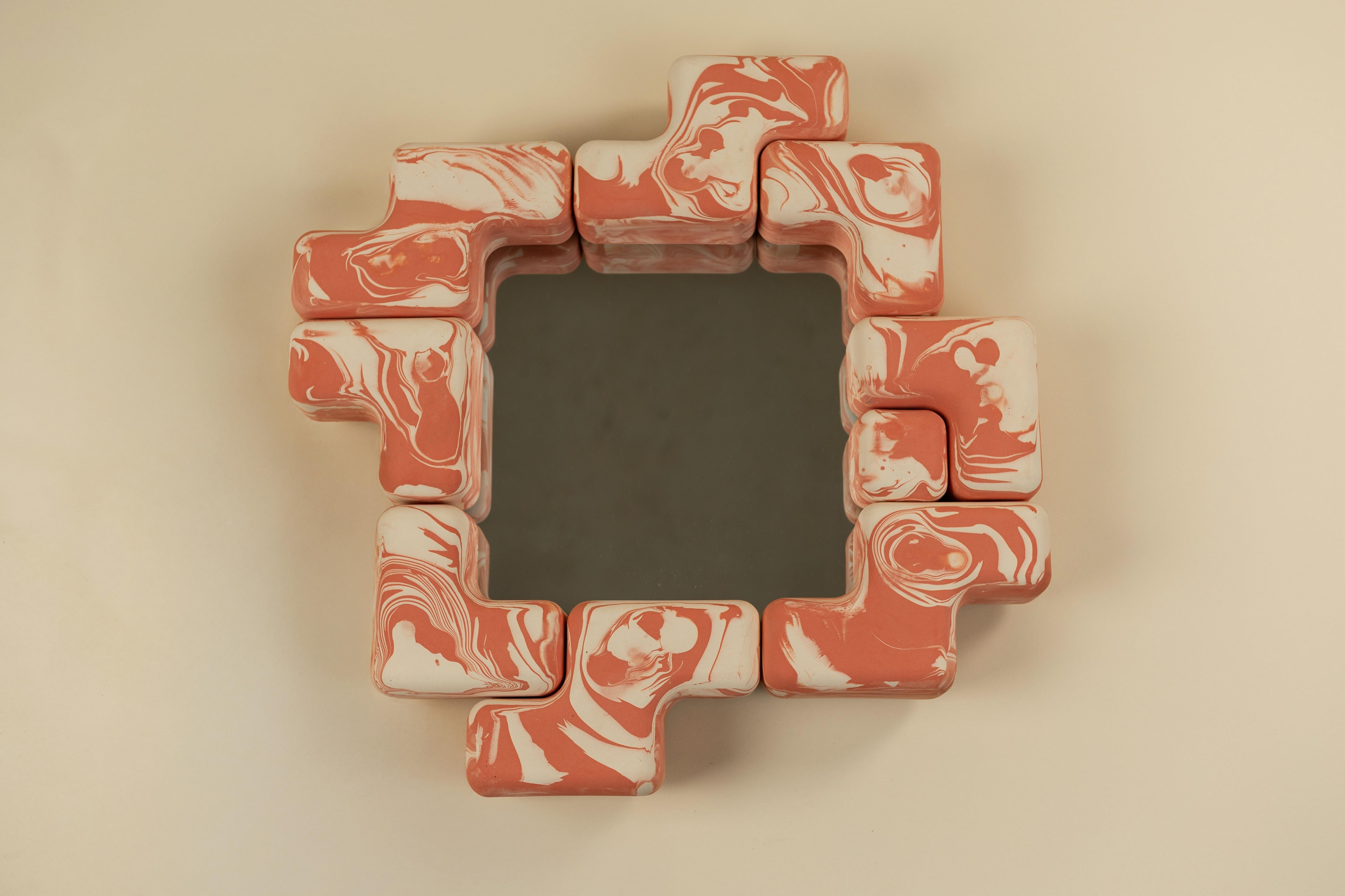 Il Cube Fit Mirror è uno specchio da parete scultoreo realizzato con forme di ceramica modulari a incastro. Fusa a mano negli Stati Uniti, l'audace cornice circonda uno specchio di vetro quadrato, creando un ritmo giocoso di geometrie ripetute. Ogni