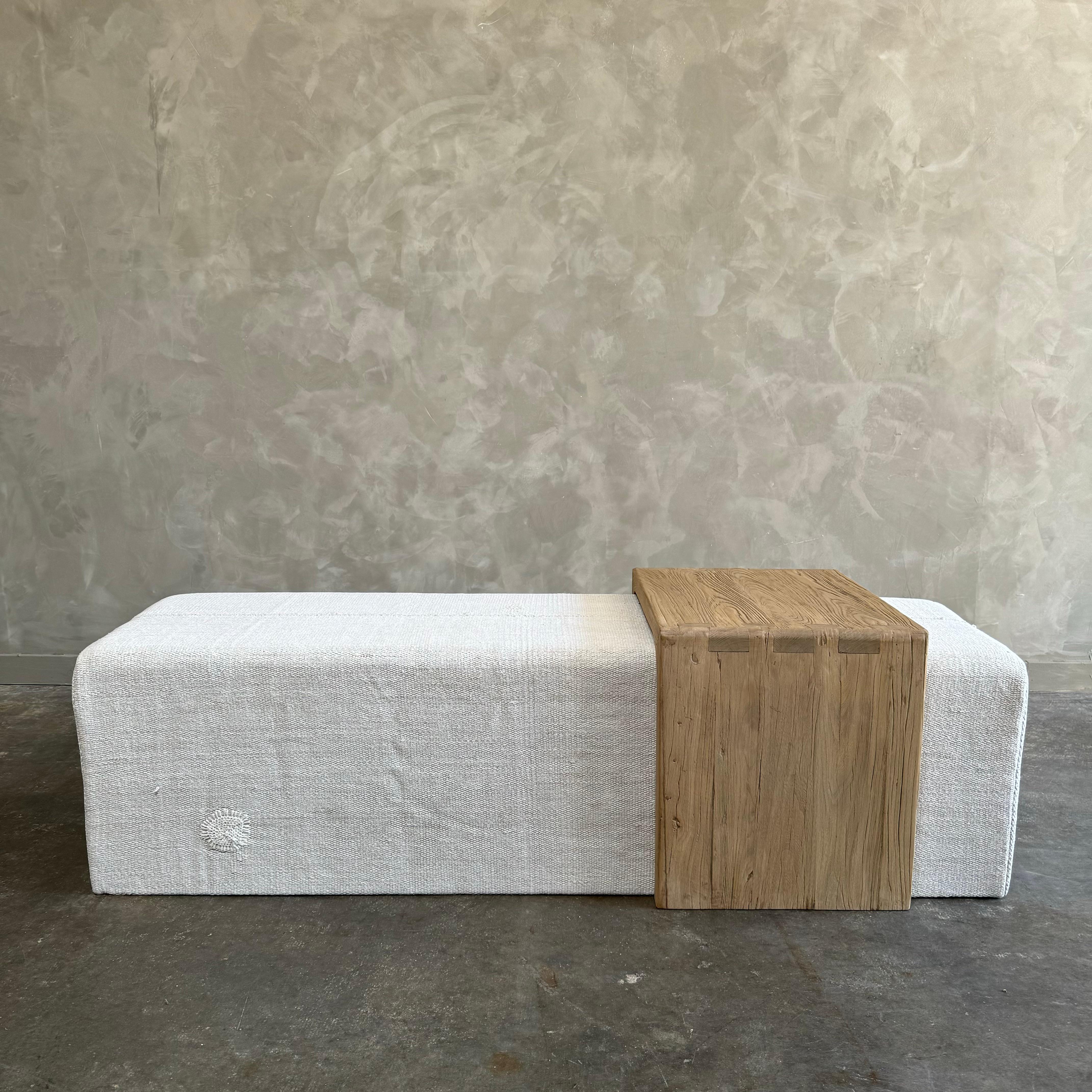 Our cube ottoman is upholstered in a beautiful hemp rug. A light color give this a versatile style. The hand-crafted solid elm wood waterfall has unique characteristics with beautiful grain and texture.