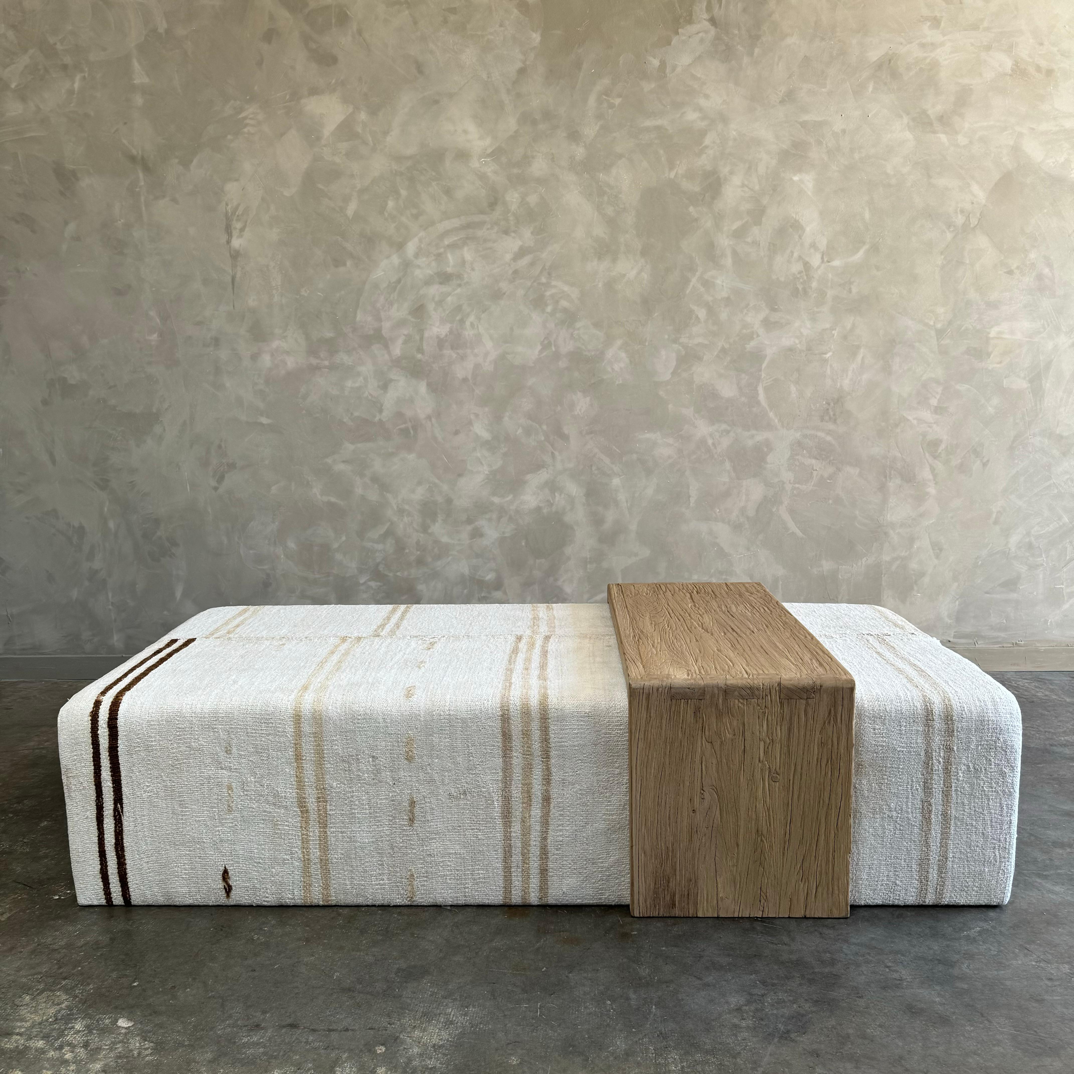 Our cube ottoman is upholstered in a beautiful hemp stripe rug. A light color with flax, dark natural stripes give this a versatile style. The hand-crafted solid elm wood waterfall table has unique characteristics with beautiful grain and