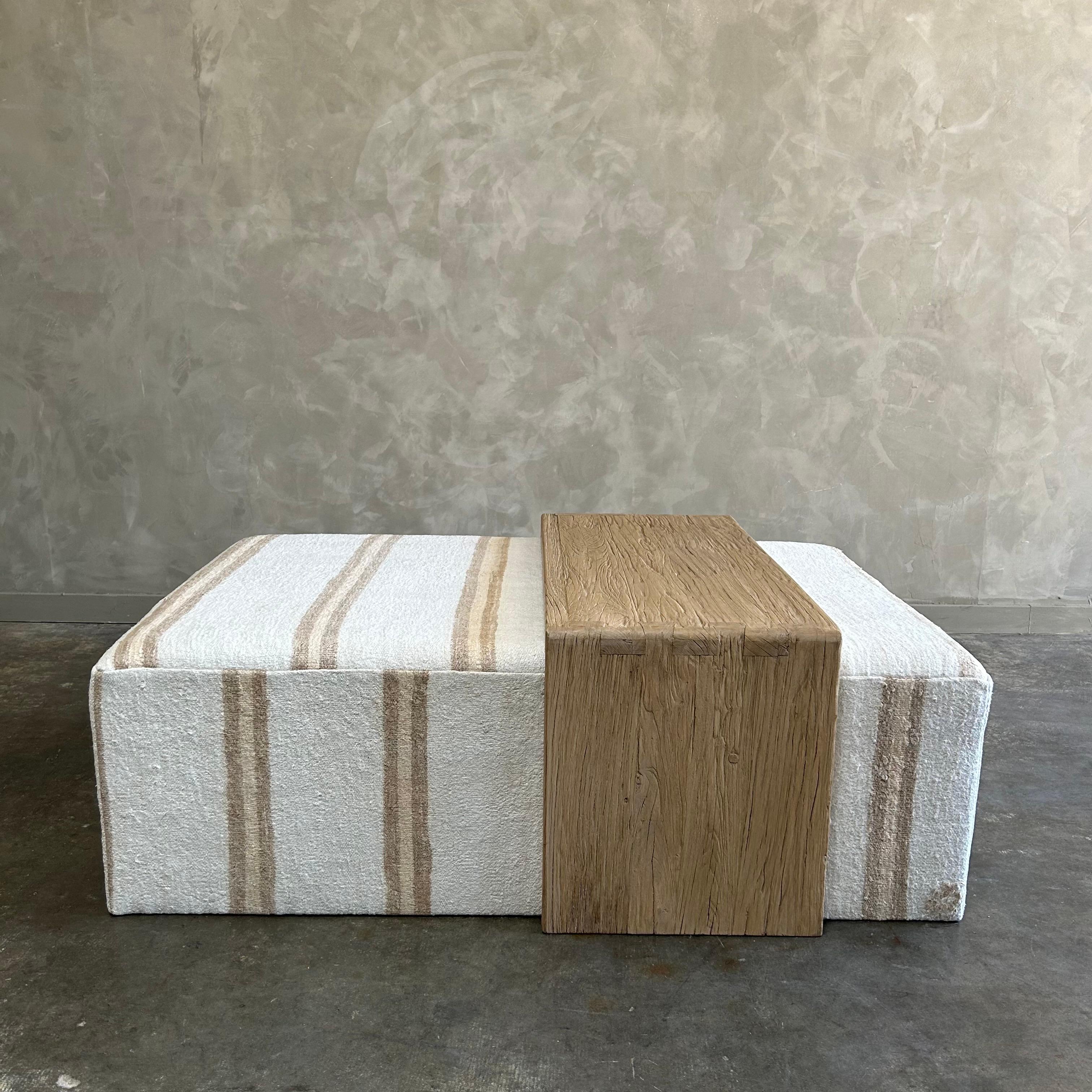 Our cube ottoman is upholstered in a beautiful hemp rug with stripes. A light color with flax natural stripes give this a versatile style. The hand-crafted solid elm wood waterfall has unique characteristics with beautiful grain and texture.