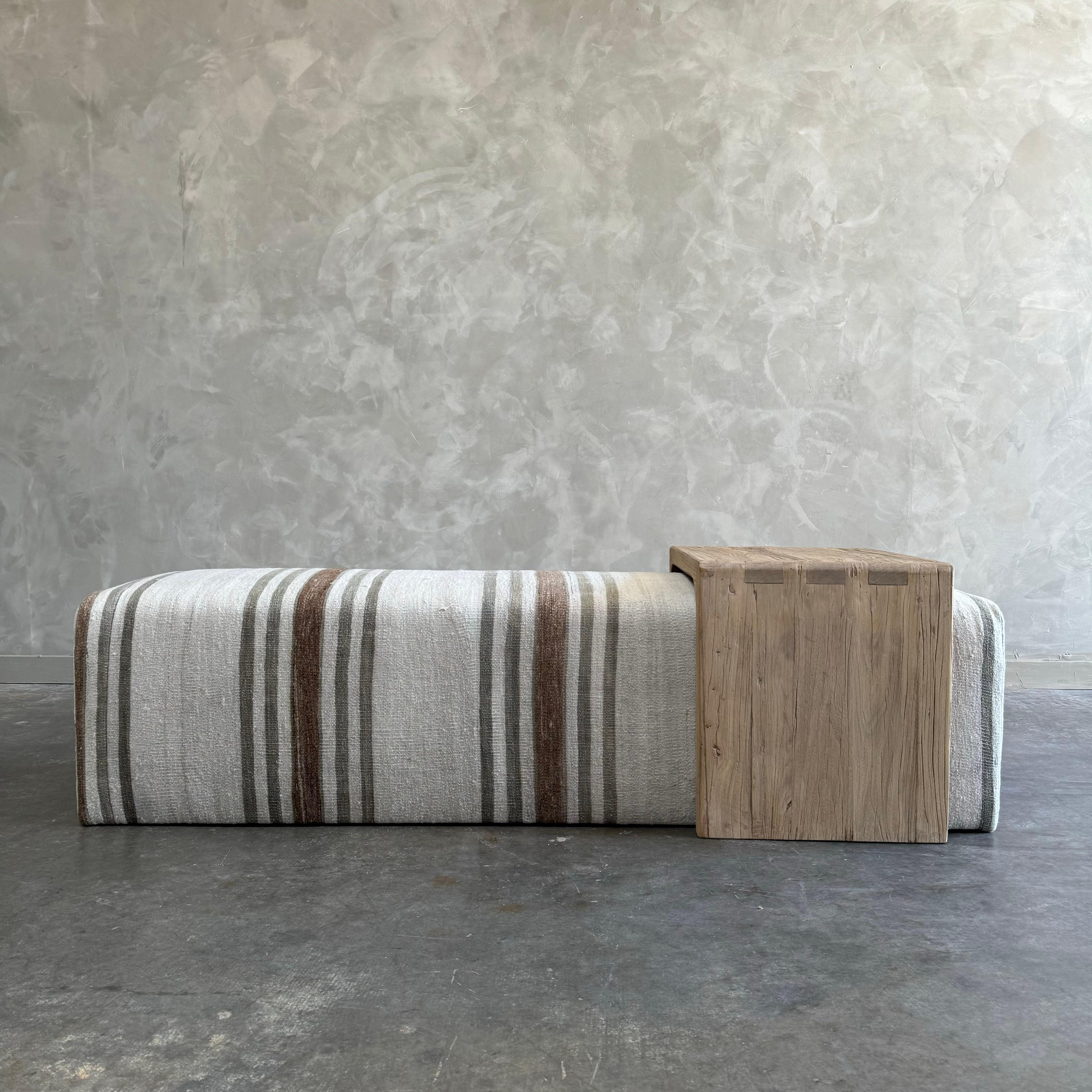 Our cube ottoman is upholstered in a beautiful hemp rug with stripes. A light color with flax natural stripes give this a versatile style. The hand-crafted solid elm wood waterfall has unique characteristics with beautiful grain and