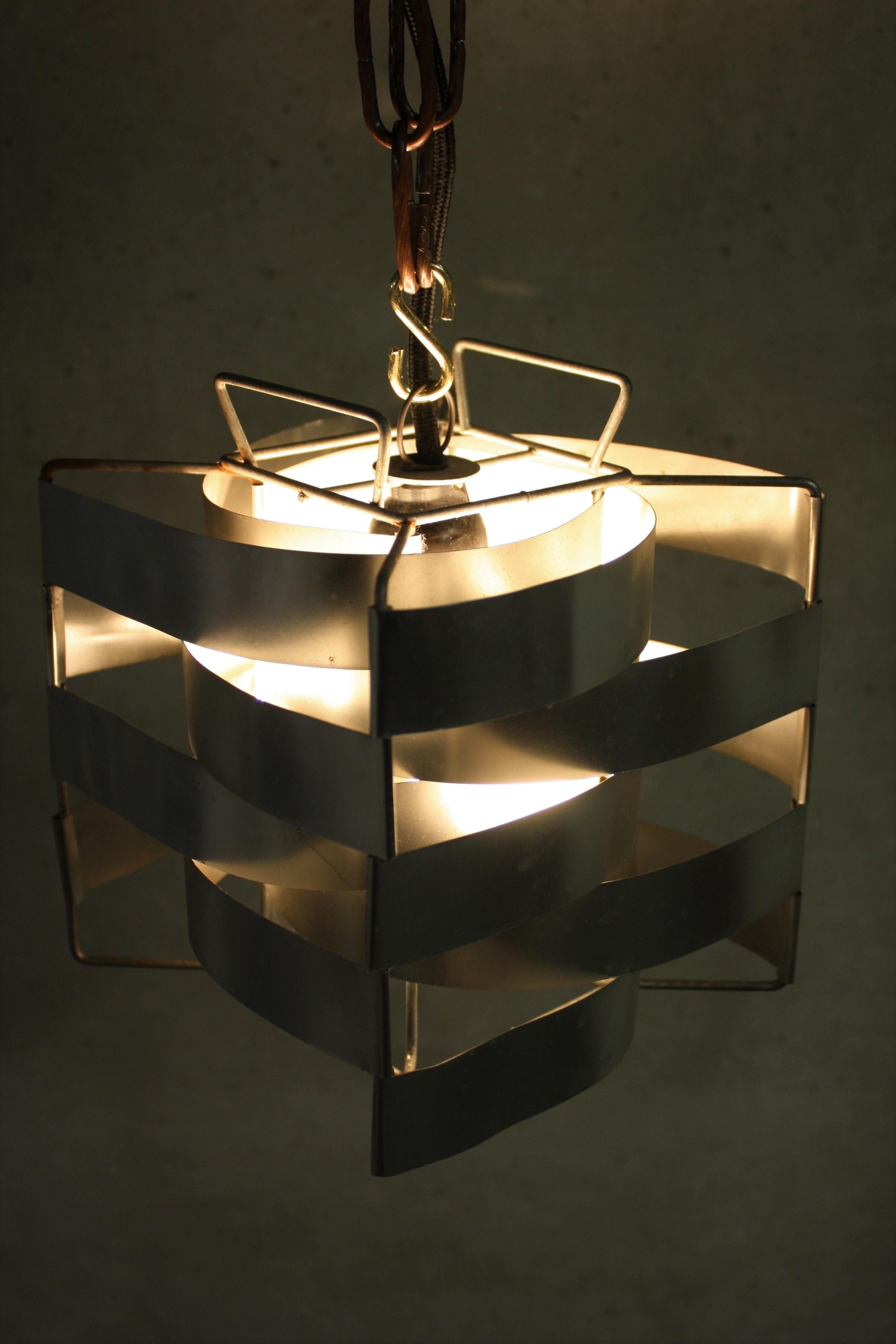 This fantastic cube pendant lamp was designed by the sculptor Max Sauze for the Max Sauze Studio in the 1970s.

The wired frame holds many aluminium bent strips creating a cube structure. 

It creates a warm and amazing light effect.

1970s,
