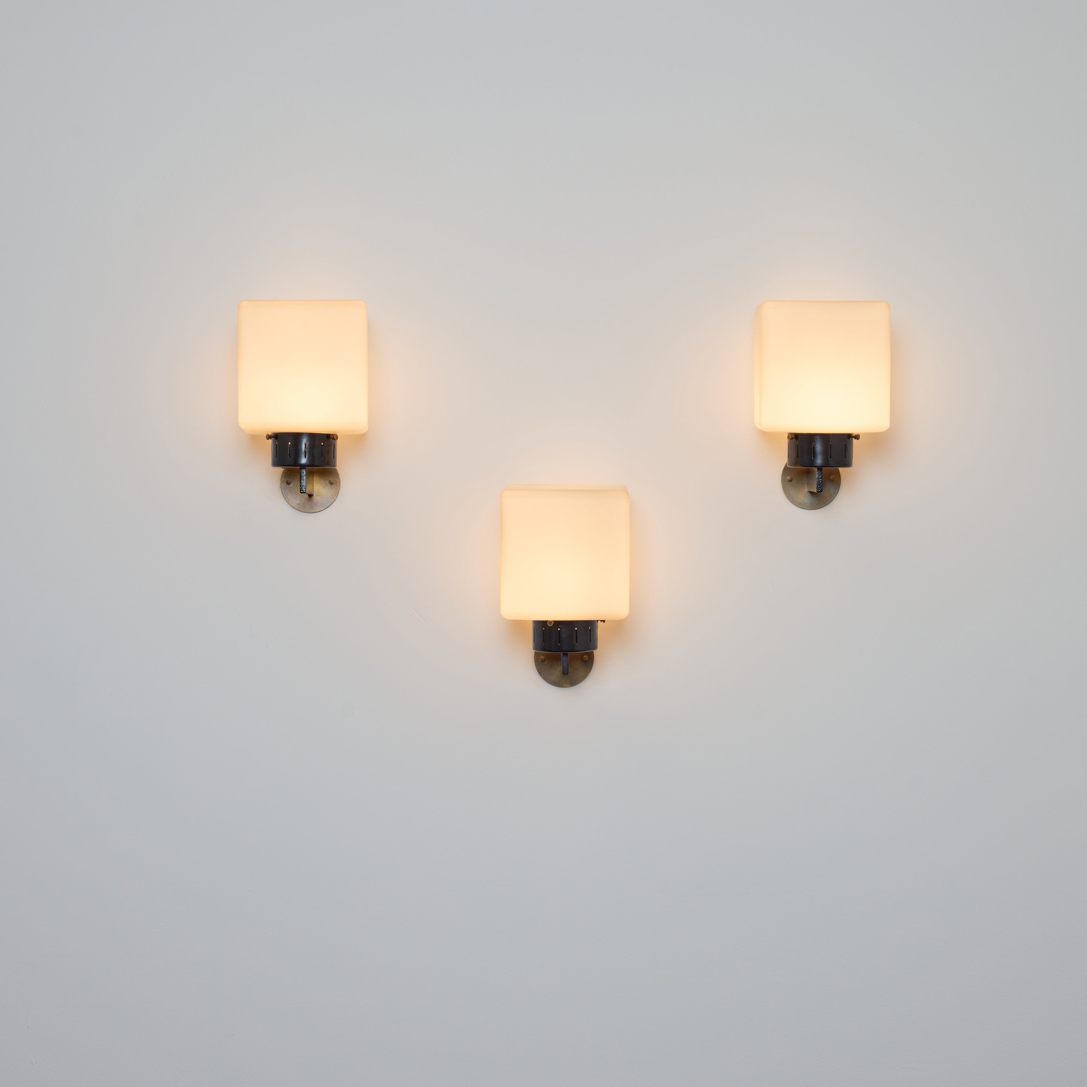 Cube shaped sconces by Stilnovo. Manufactured in Italy, circa 1960s. Brushed satin glass, painted metal, brass. Custom brass backplates. Rewired for U.S. standards. Fully restored. Each fixture has one socket. We recommend one E27 25-60w maximum