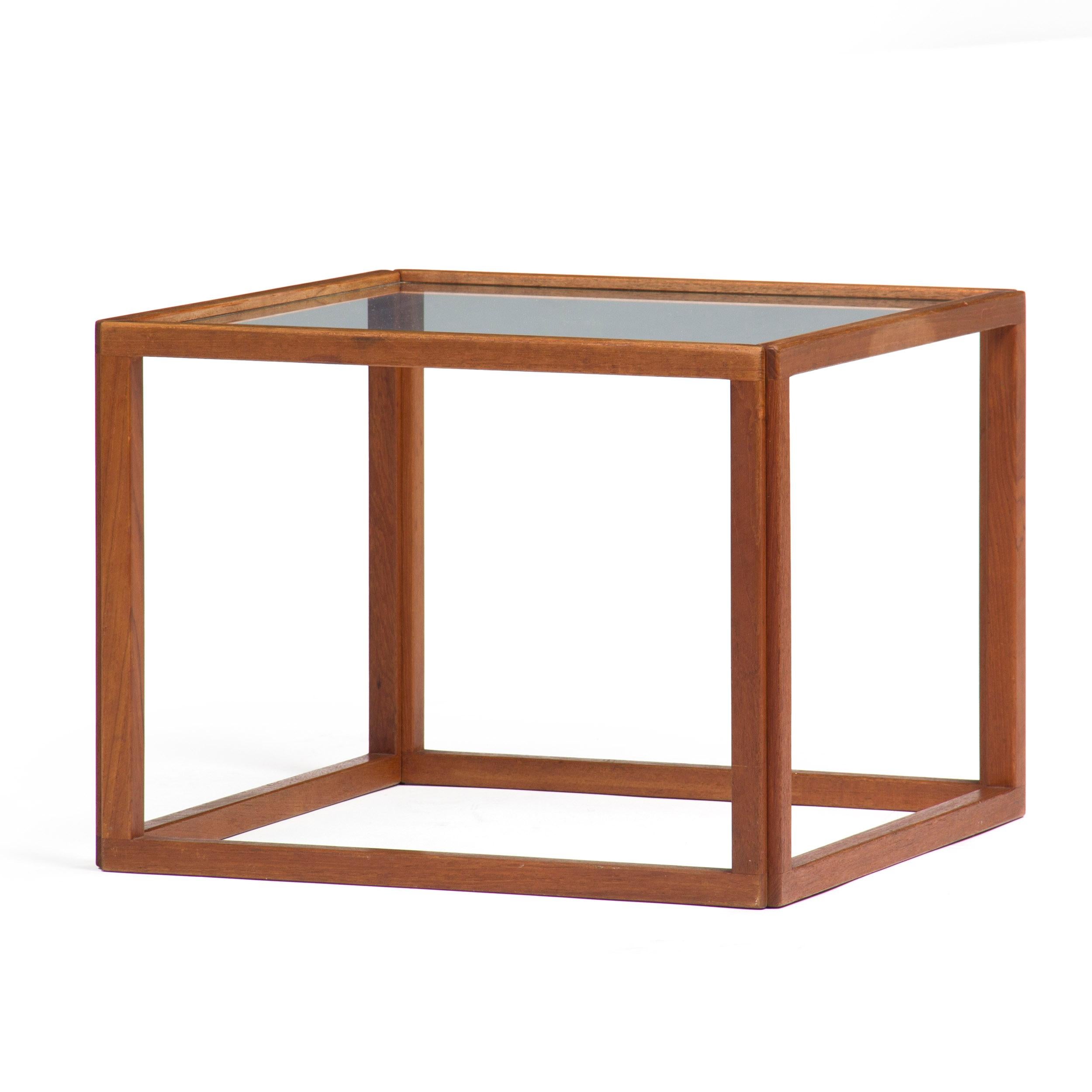 A solid teak open cube side table with a glass top. Designed by Kai Kristiansen and manufactured in Denmark in the 1950s.
