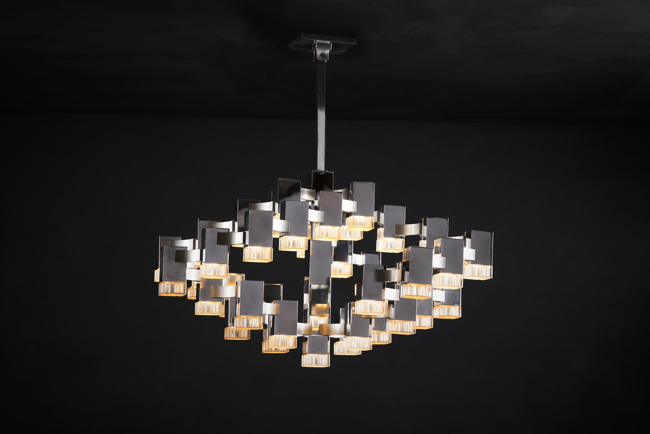 Mid-Century Modern Cubic chandelier designed by Gaetano Sciolari. This pendant consists of 37 rectangular polished chrome cubes with textured lucite shades. The hanging chain can be adjusted to suit, and the original ceiling cap is included.