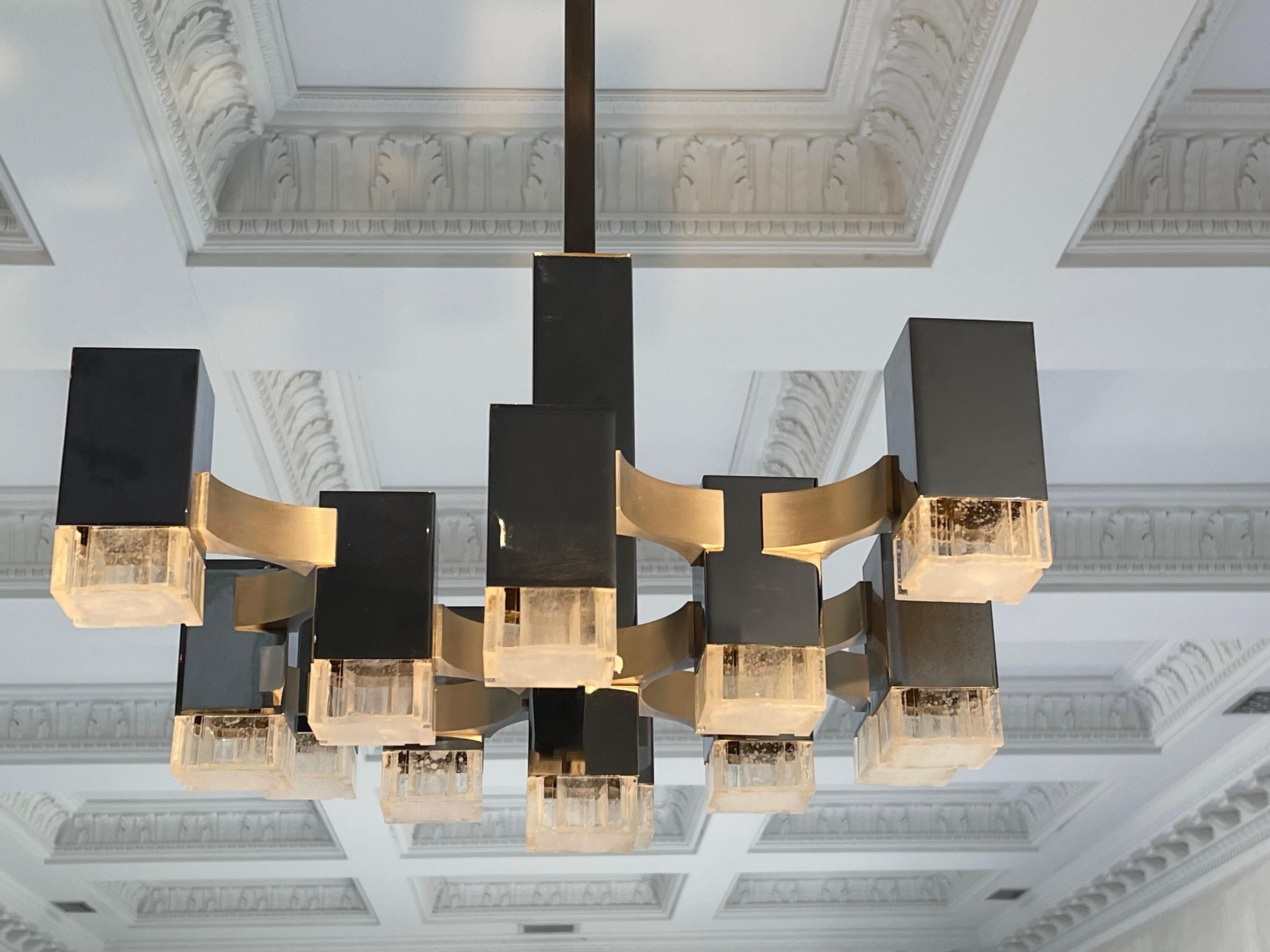 This 12 Light Cubic chandelier by Lightolier was made in Italy and was designed by Gaetano Sciolari.
The Crome cubes extend into ice cubes made of Lucite and compliment each other beautifully. The lucite is clear in color.