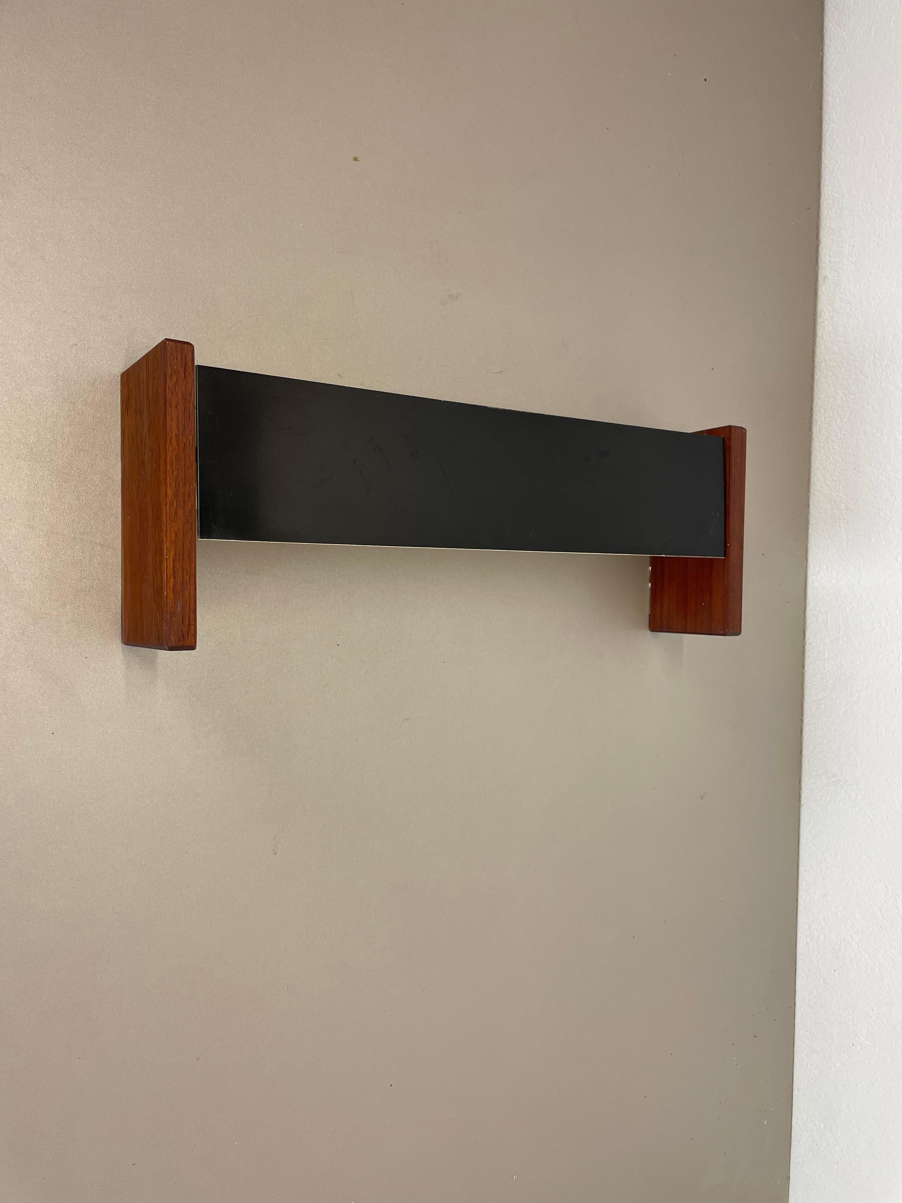 Article:

wall lights element



Origin:

Germany



Age:

1950s




This vintage modernist wall light was produced in the 1950s in Germany. very minimalist and cubic one of a kind design form the 1950s. The lights is made of metal and solid teak.