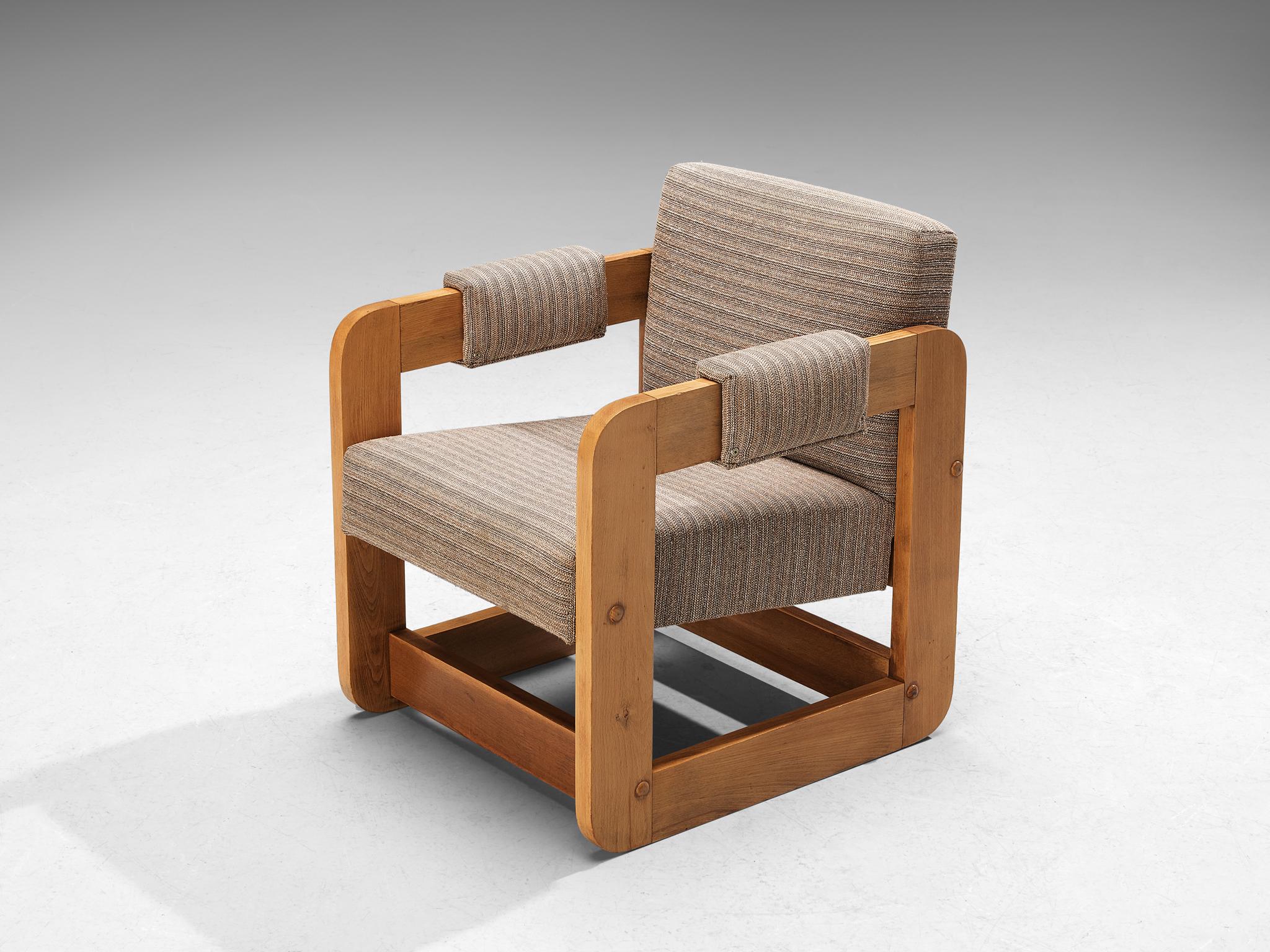 Lounge chair, beech, fabric, Europe, 1970s. 

Geometric shaped lounge chair composed of solely cubic forms. The wooden frame that function as an armrest is based on a square shape, which gives the unit an open and transparent appeal to the quite