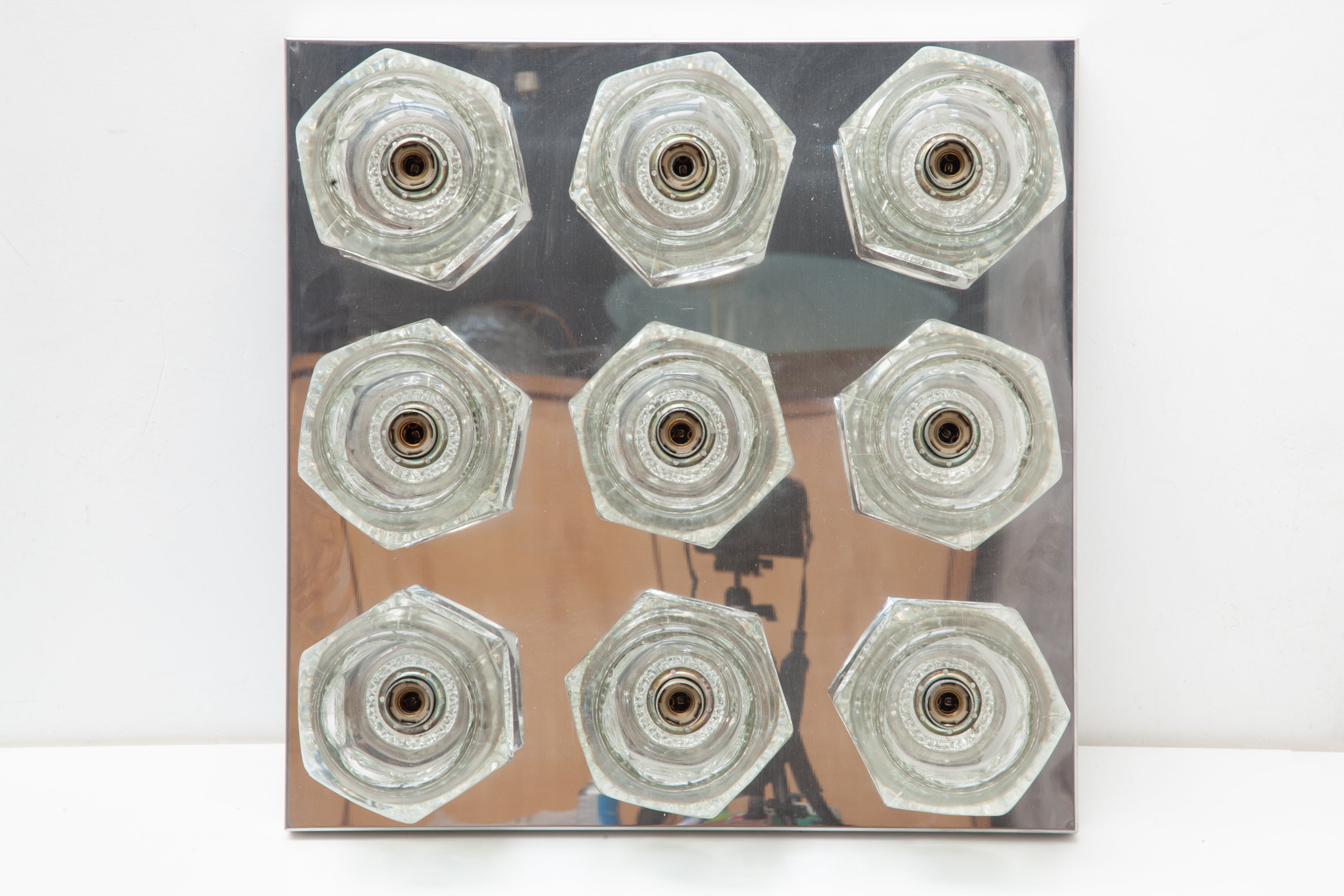 A 1970s ceiling or wall light fixture designed by Peill and Putzler, Germany.
The flush mount features 9 textured glass shades mounted on a square chrome base which reflects the light with a warm glow.
 