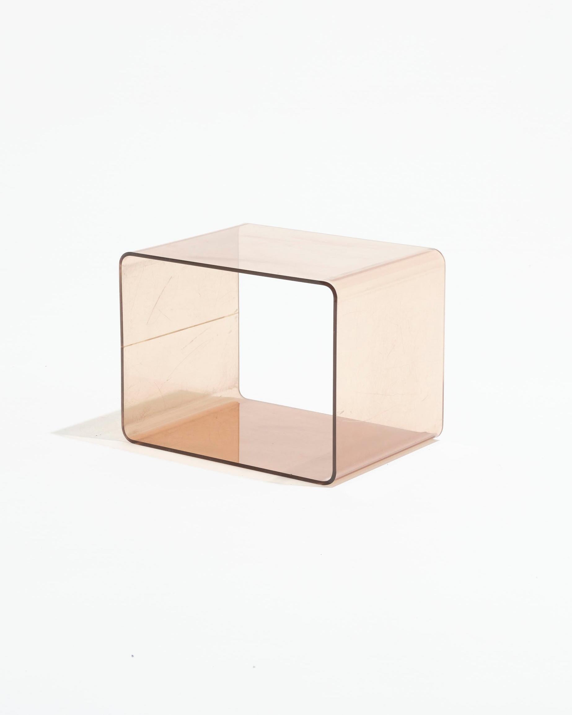 Mesa auxiliar de acrílico cúbico diseñada por Michel Dumas y fabricada en los años 70 por Roche Bobois. Una pieza icónica de la estética retrofuturista de la época. En la superficie se aprecian arañazos y signos de uso, acordes con la antigüedad de