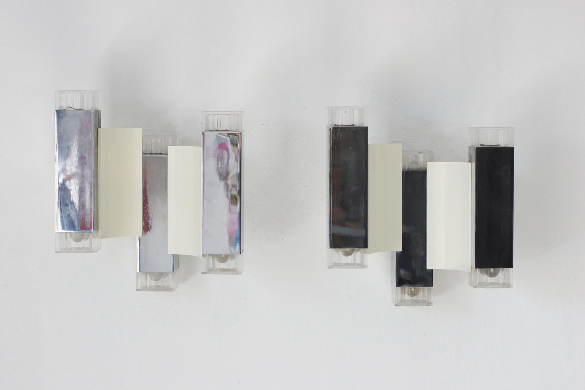 Les lampes murales de Cubic Design by Gaetano Sciolari sont des icônes du design italien des années 1960 et 1970, combinant des éléments du modernisme avec des influences du brutalisme, ce qui est évident dans les lignes distinctives. 
 
Les