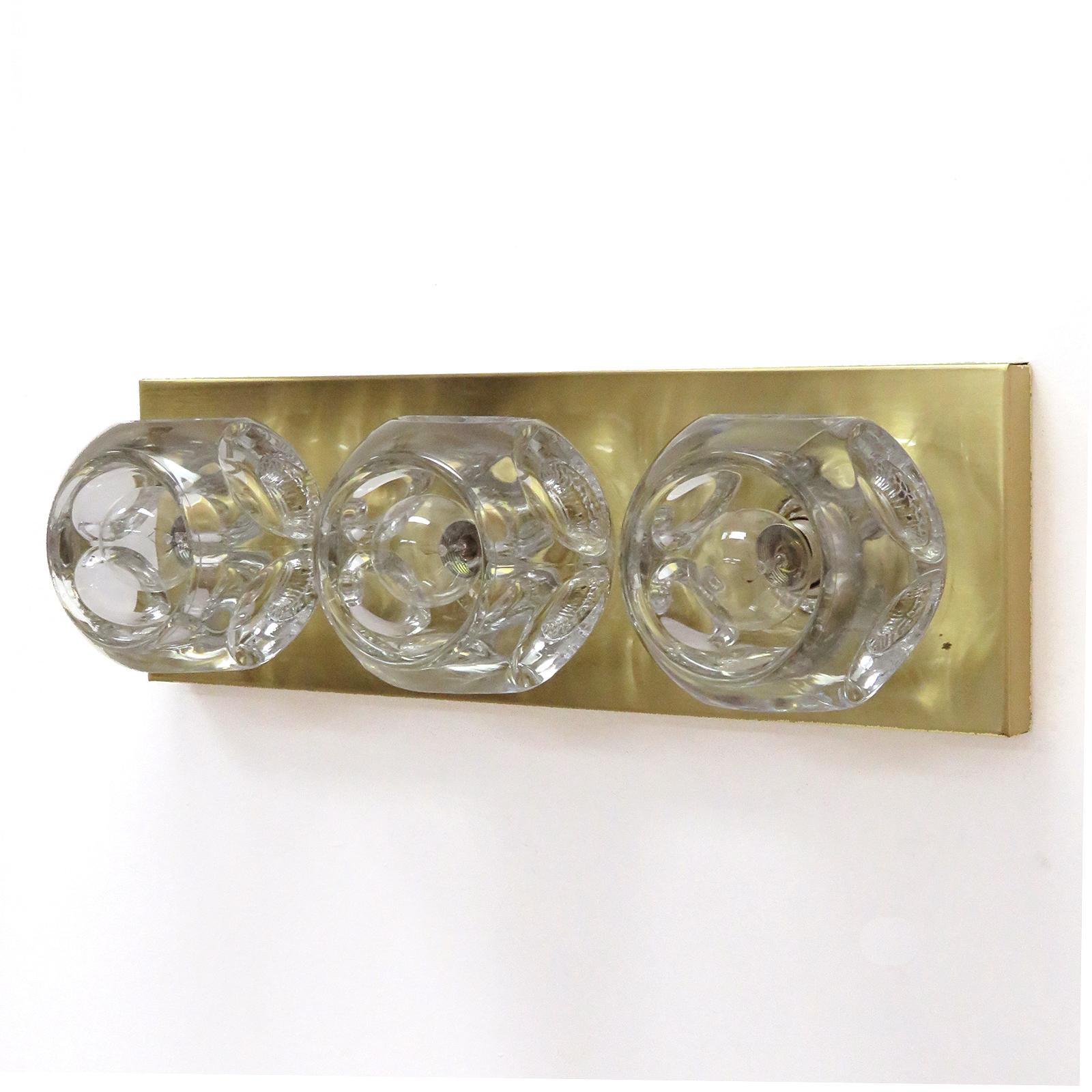 wonderful cubic wall light by Peill & Putzler, Germany, with three large faceted, solid glass spheres with artful bubble inclusions, mounted to a brass plate, horizontally or vertically, optional use as a ceiling flush mount, marked, wired for US