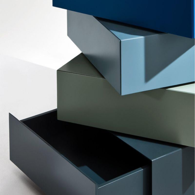 This rotating, sectional dresser with three drawers piled on a common base is a piece designed to impress with its extraordinary sculptural flair. The drawers and base are in glossy polyester-lacquered wood, offered in a harmonious palette of blues