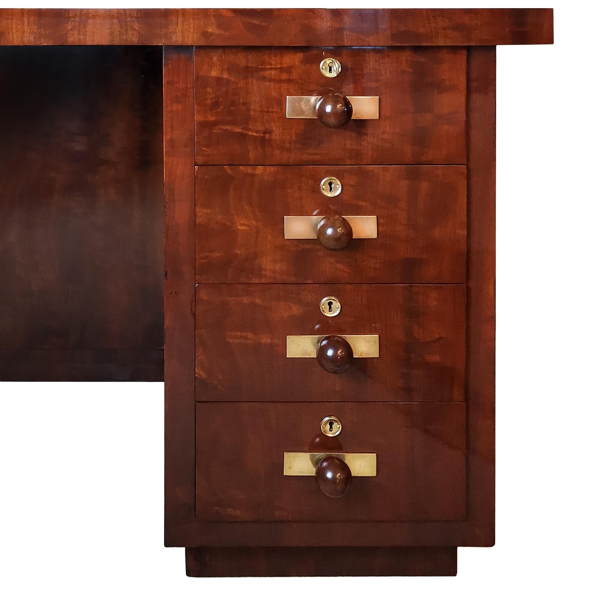 Kubistischer Art-Deco-Schreibtisch mit geflammtem Mahagoni-Furnier. Sechs Schubladen und eine Türöffnung auf der Vorderseite, eine Nische auf einer Seite. Griffe aus Mahagoni, polierte Messingbeschläge. Französisch polnisch. Sehr hohe