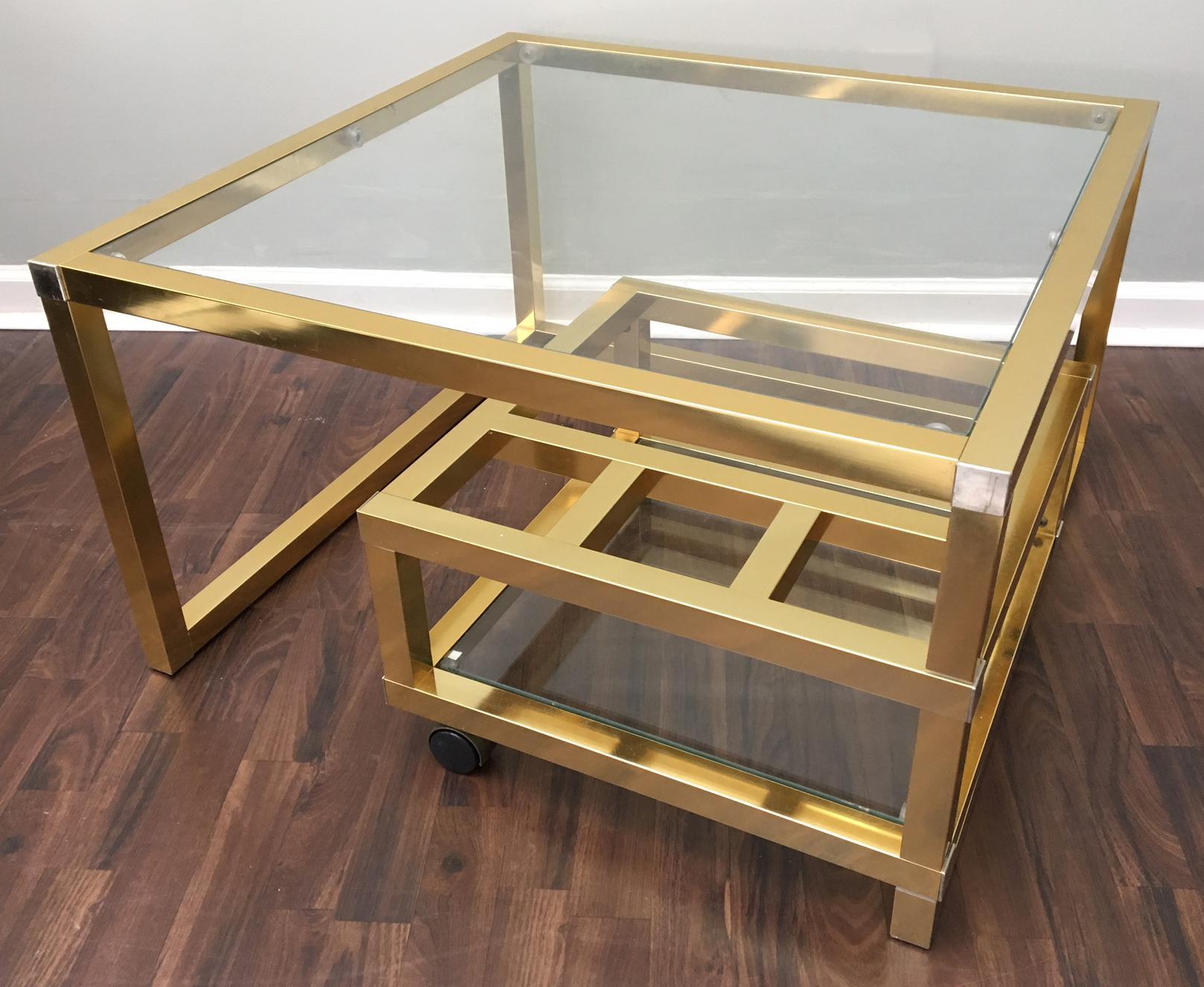 Mid-Century Modern brass coffee table inspired by Paul Evans, MIlo Baughman, and Maison Jansen.
Brass and chrome modernist coffee table features swing-out section with wine rack and glass shelf. 
Good vintage condition with minor wear consistent