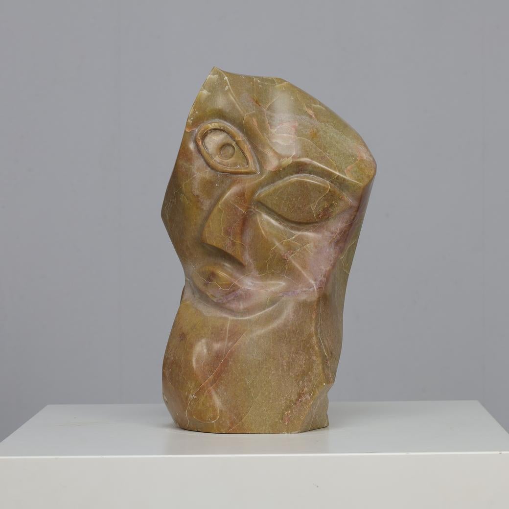This powerful marble head sculpture reflects the influence of Cubism, the groundbreaking movement pioneered by artists such as Picasso and Braque. With its intersecting planes, faceted geometry, and abstraction of the human face, the piece captures