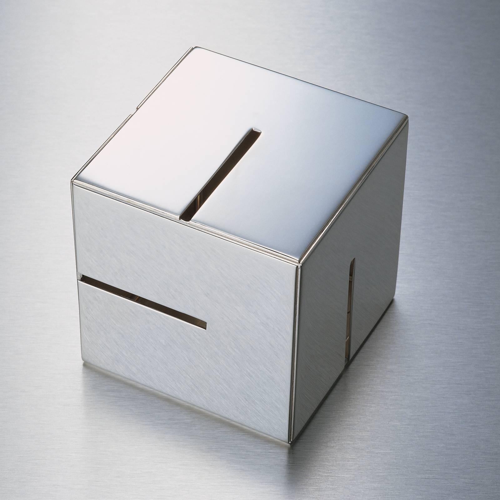 Designed by Piero Lissoni in 2001 and crafted of 925/1000 silver, this piggy bank is a stunning piece of decor that can be displayed as sculpture in a contemporary home. Its geometric silhouette is a perfect cube, whose identical sides are adorned