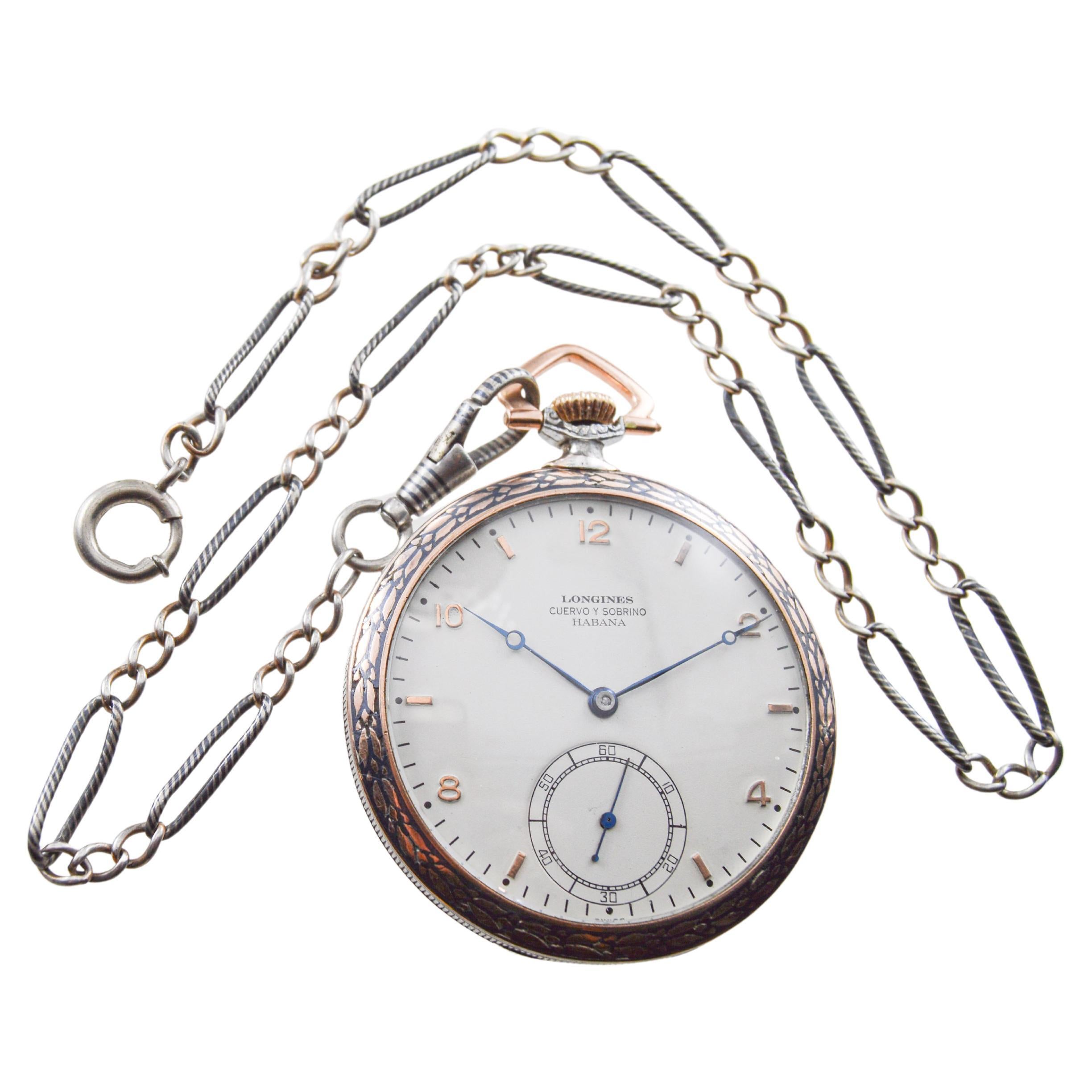 FACTORY / HOUSE: Longines for Cuervo & Sobrinos 
STYLE / REFERENCE: Open Faced Pocket Watch / Art Deco
METAL / MATERIAL: Silver / Rose Gold and Niello Inlayed
CIRCA / YEAR: 1940's
DIMENSIONS / SIZE: Length & Diameter 46mm
MOVEMENT / CALIBER: Manual