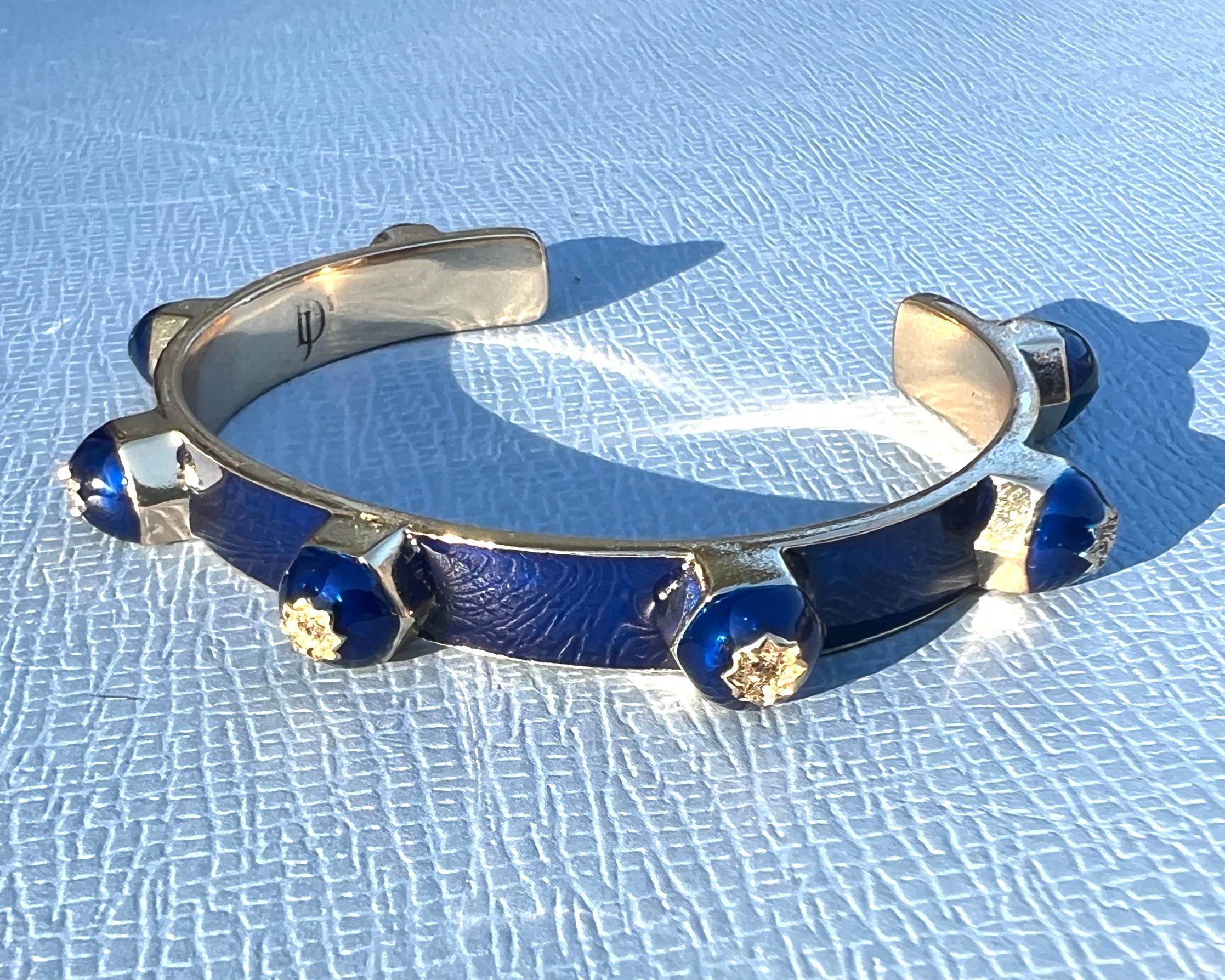 Manschettenarmband Blau Emaille Diamant Viktorianisch Beschreibung

Das Cuff Bracelet Blue Enamel Diamond Victorian ist ein handgefertigtes Stück von J DAUPHIN, das viktorianisch inspiriertes Design mit spiritueller Symbolik verbindet. Diese